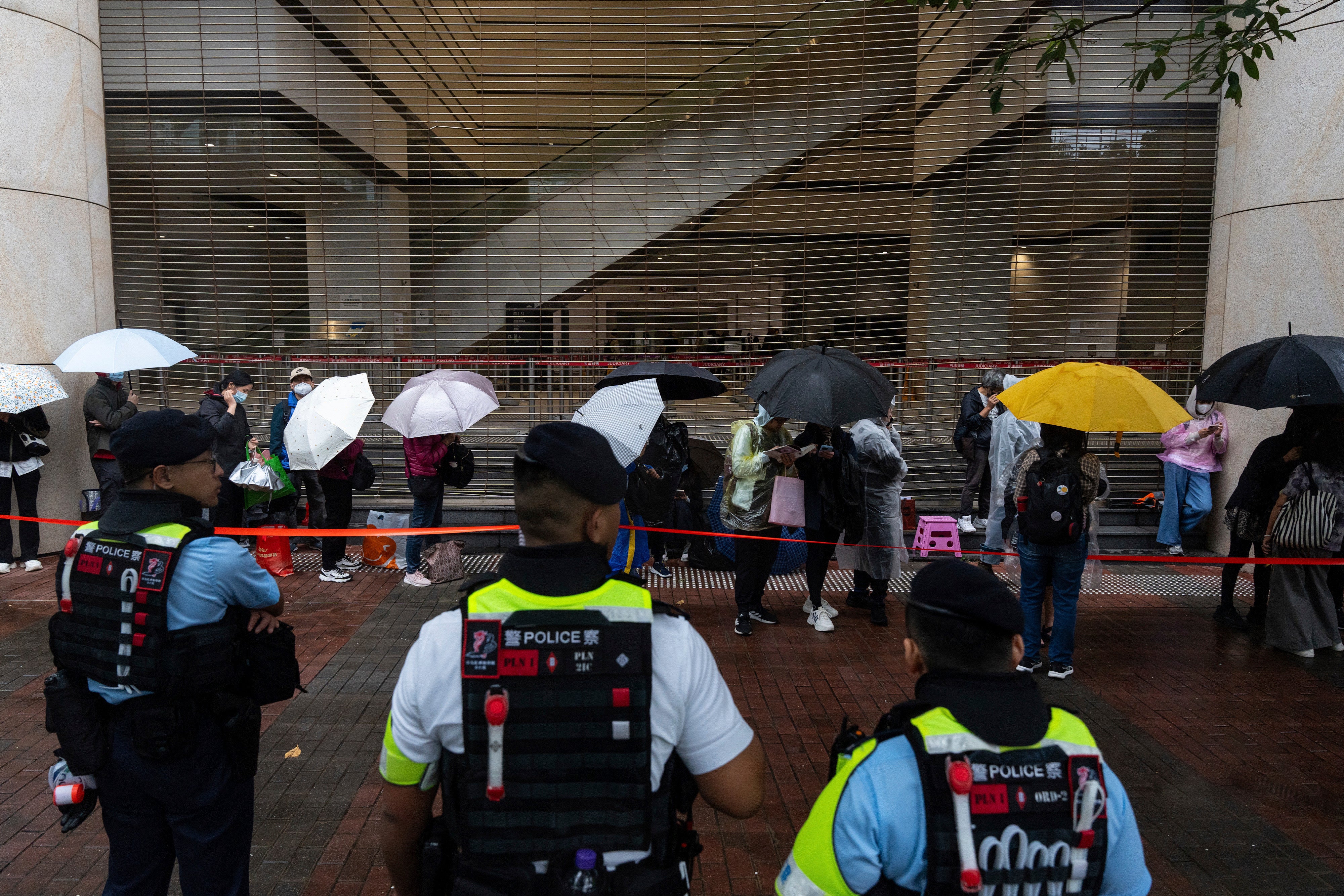 People wait outside the West Kowloon Magistrates’ Courts in Hong Kong Tuesday, 19 November 2024