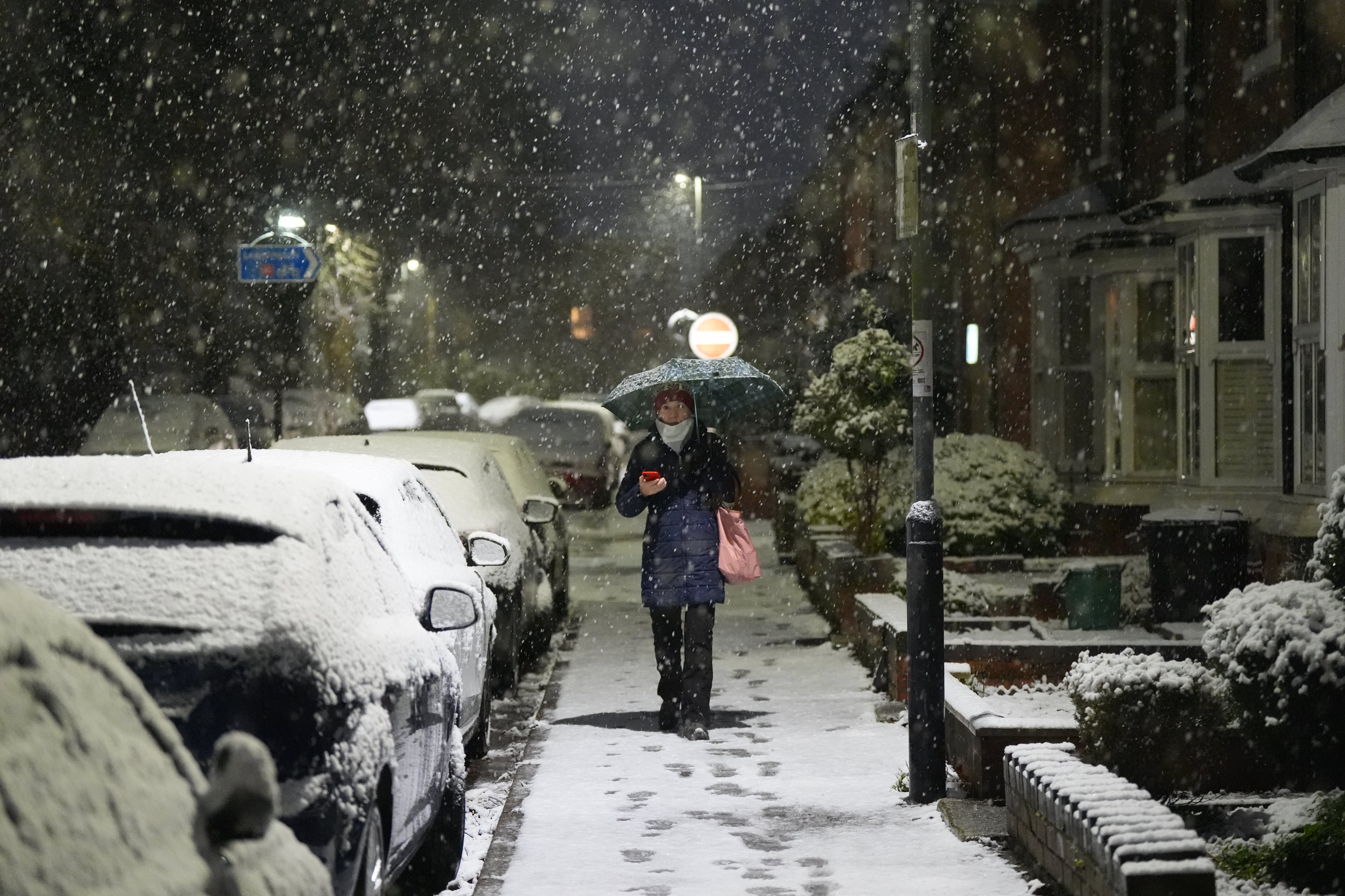 A woman walks through snow in Warwick as the UK braces for travel chaos