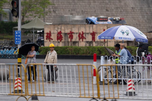 <p>Residents pass near the sign for Zhuhai Sports Center where a man rammed his car into people exercising at the sports center, killing and injuring dozens of people in Zhuhai in southern China's Guangdong province, Nov. 14, 2024. (AP Photo/Ng Han Guan), File)</p>