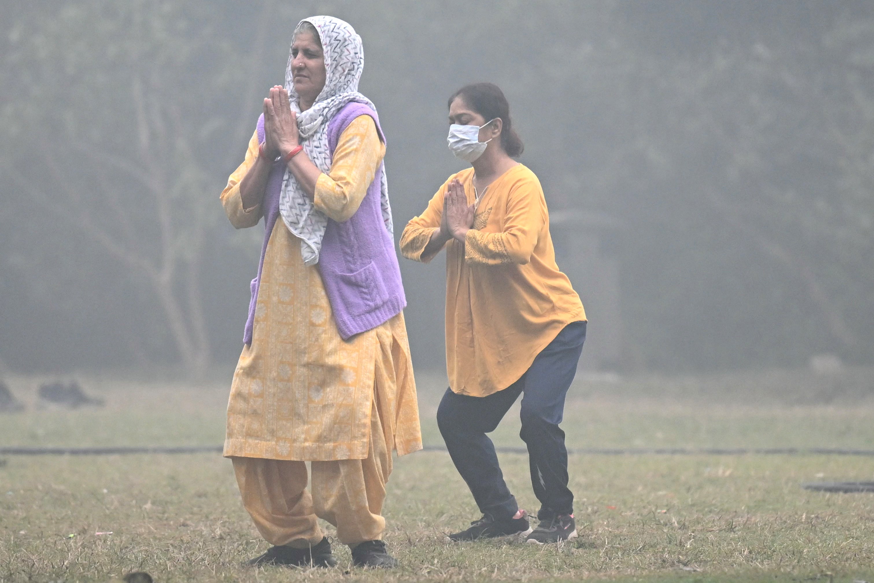 Women wear masks as they exercise at the Lodhi Garden in New Delhi