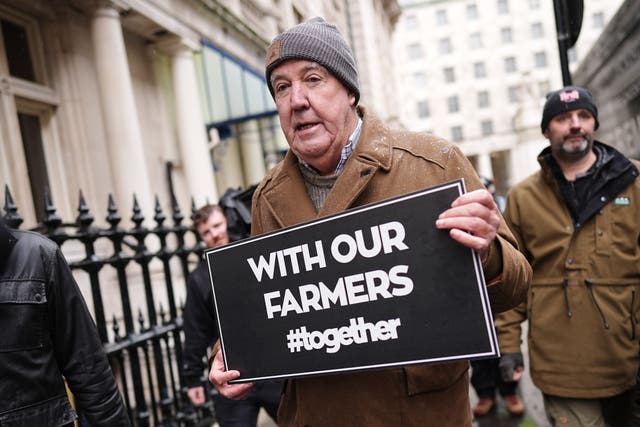 <p>Jeremy Clarkson holding a sign that says ‘with our farmers’
</p>