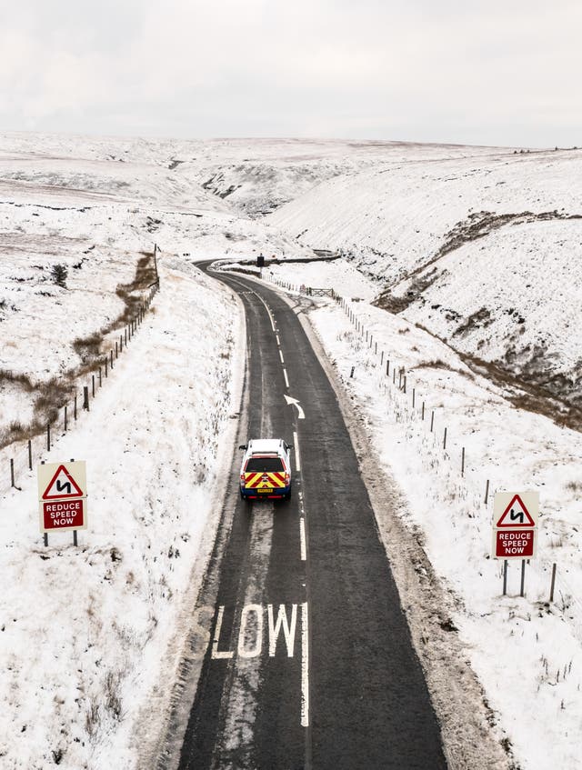 <p>Cars driving down the snow-covered Snake Pass</p>