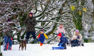 People play in the snow on the hills of Buxton, Derbyshire