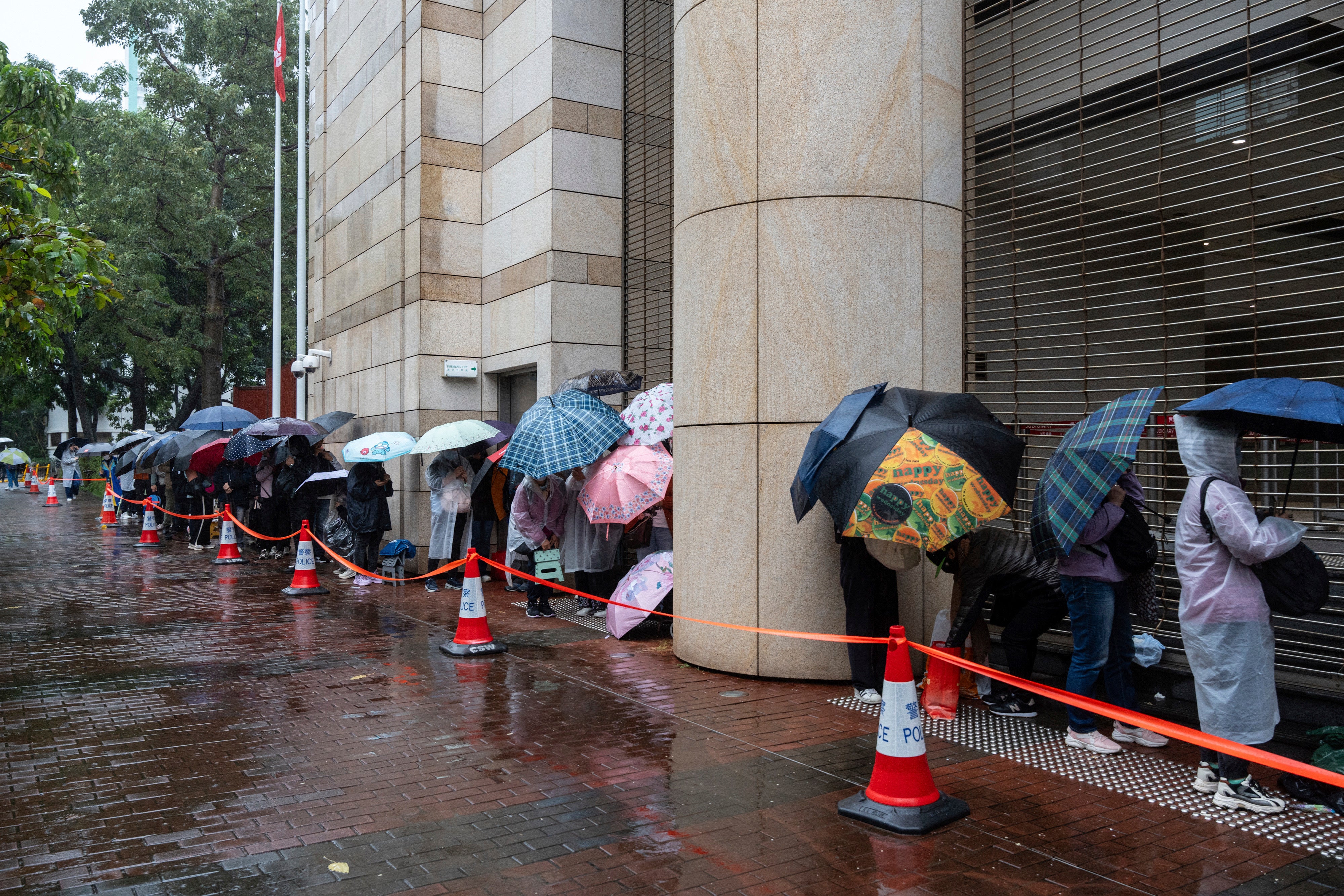 People wait to enter the West Kowloon Magistrates’ Courts in Hong Kong, Wednesday, 20 November 2024, ahead of Hong Kong activist publisher Jimmy Lai’s national security trial