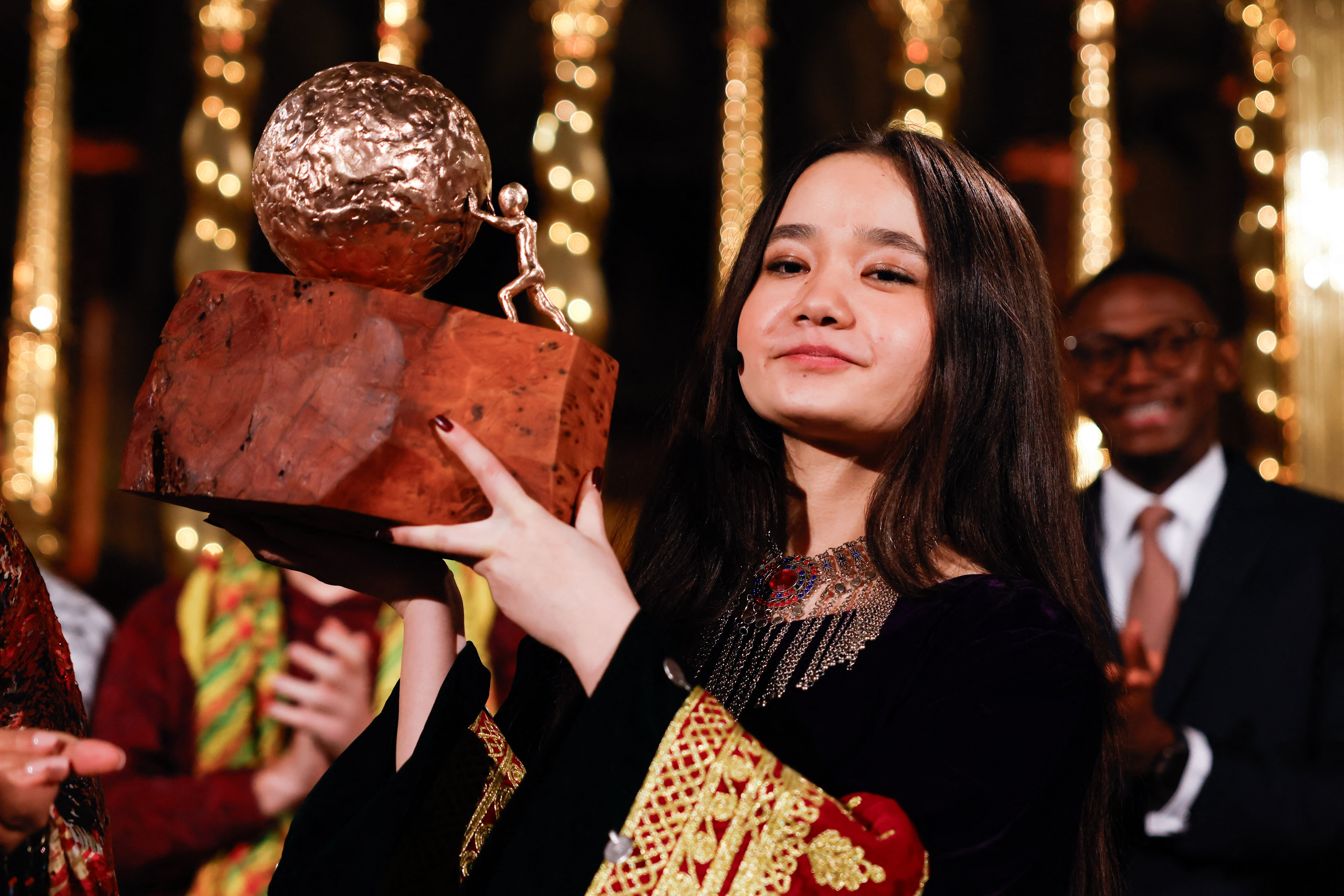 Nila Ibrahimi, a 17-year-old Afghanistan-native girls' right activist, holds her prize after winning the KidsRights International Children's Peace