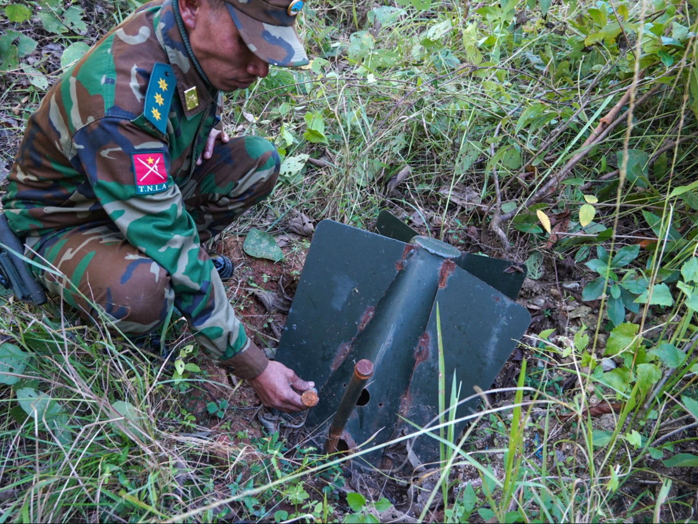 This photo taken on 17 November 2024 shows a member of Ta’ang National Liberation Army (TNLA) handling a Myanmar military’s unexploded ordnance in Mantong town, northern Shan State. Landmines and unexploded munitions claimed more victims in Myanmar than in any other country last year, a monitor said on 20 November 2024 with over 1,000 people killed or wounded in the country