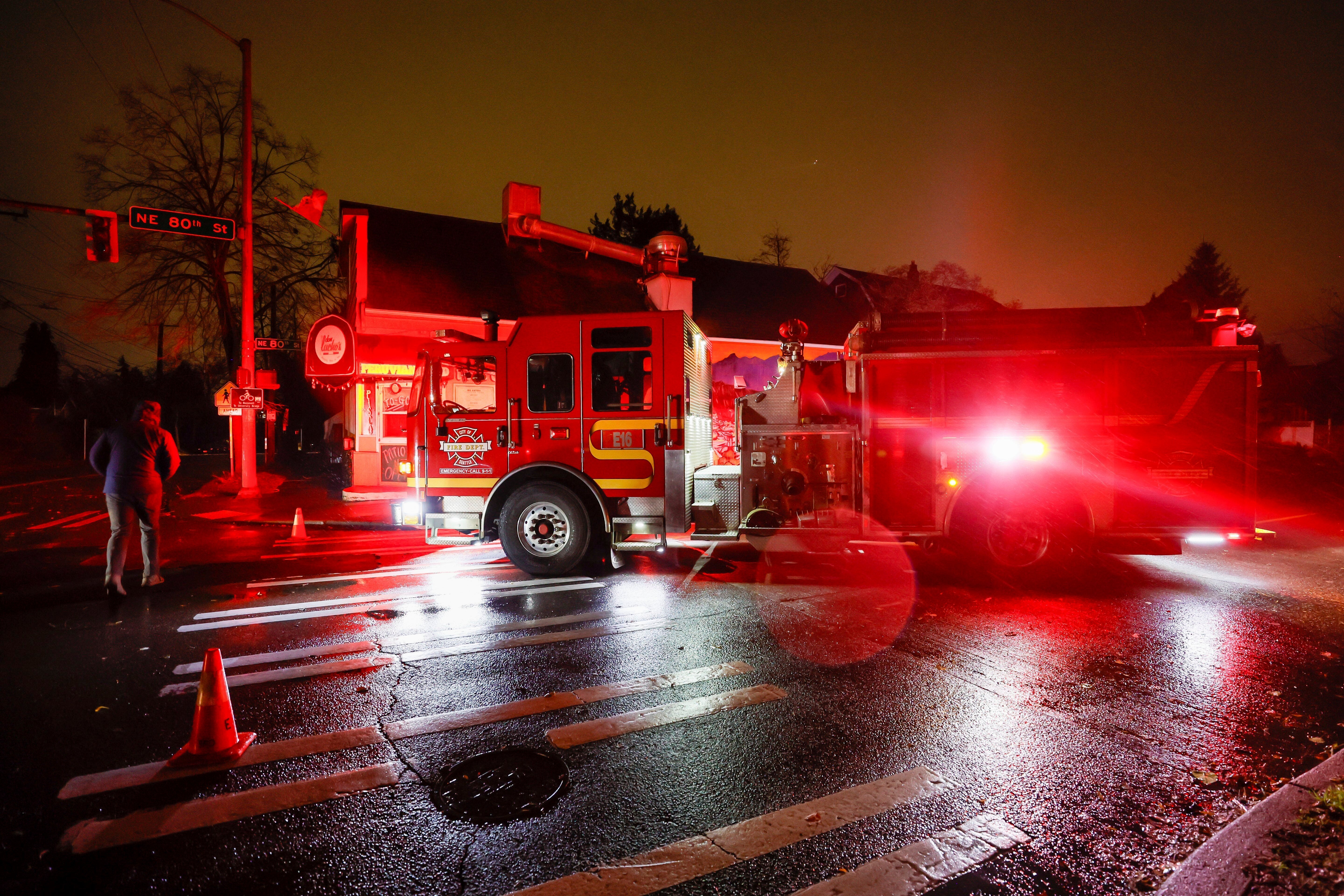 A firetruck blocks NE 80th St. at Roosevelt after power lines fell across the street during a major storm on Tuesday in Seattle