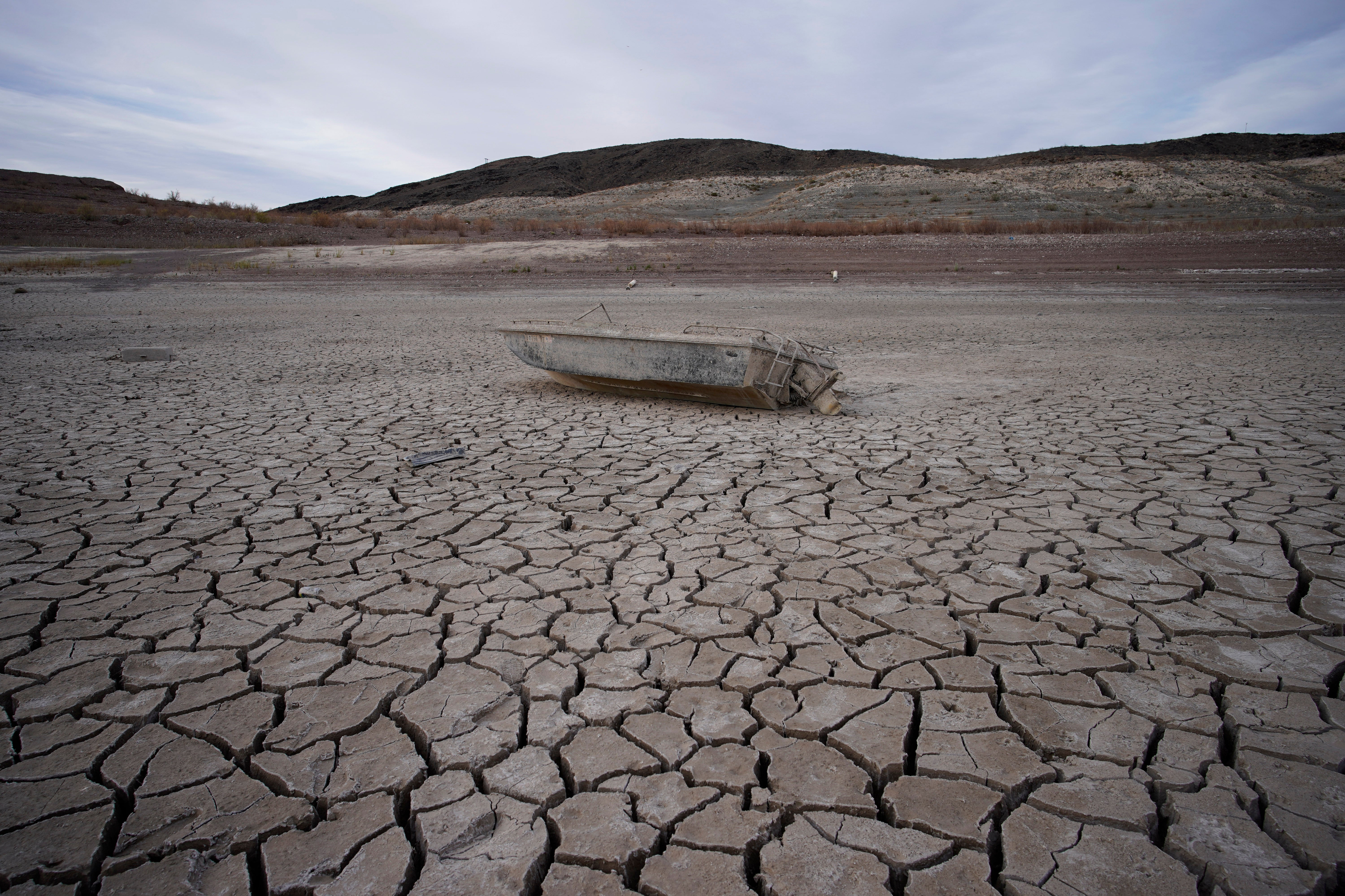 A formerly sunken boat sits on cracked earth hundreds of feet from the shoreline of Lake Mead, a reservoir formed by the Hoover Dam on the Colorado River