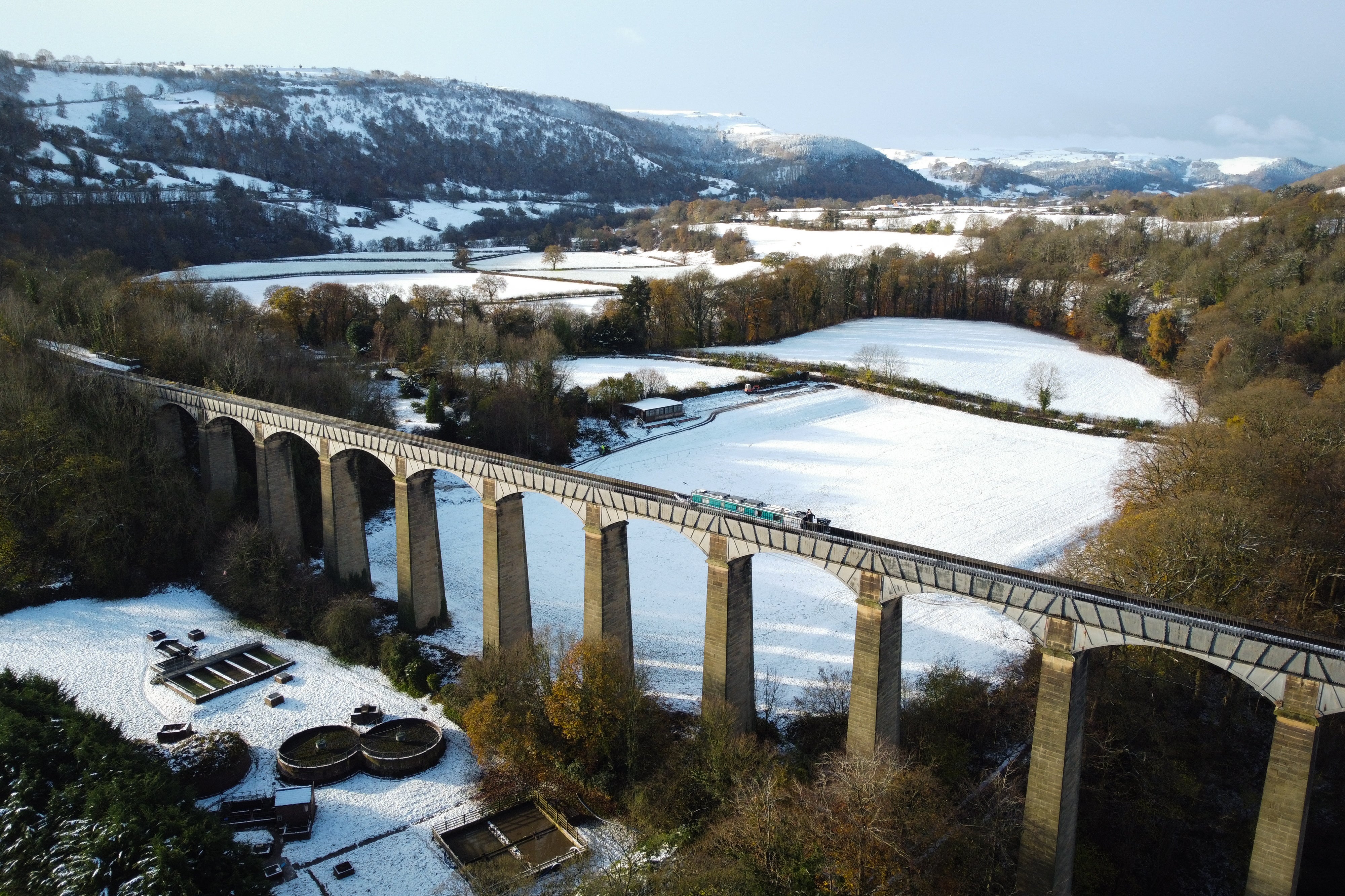 An aerial photograph taken by drone of a canal boat passing over the Pontcysyllte Aqueduct