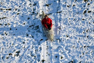 A person sledges down a hill in a canoe near Dorchester