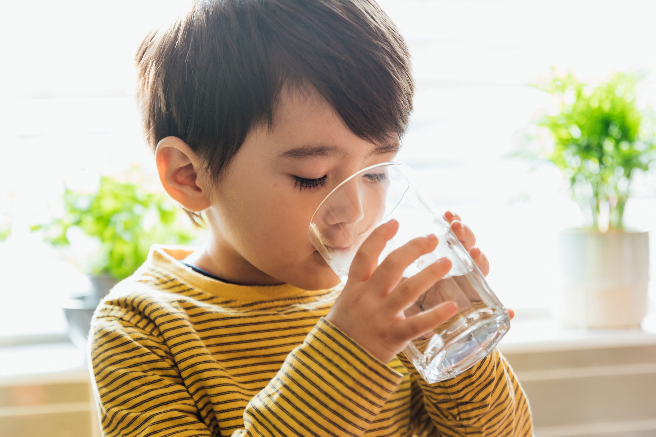 A young boy drinks a glass of water. Researchers have identified a previously unknown chemical compound in US drinking water that could affect millions of Americans