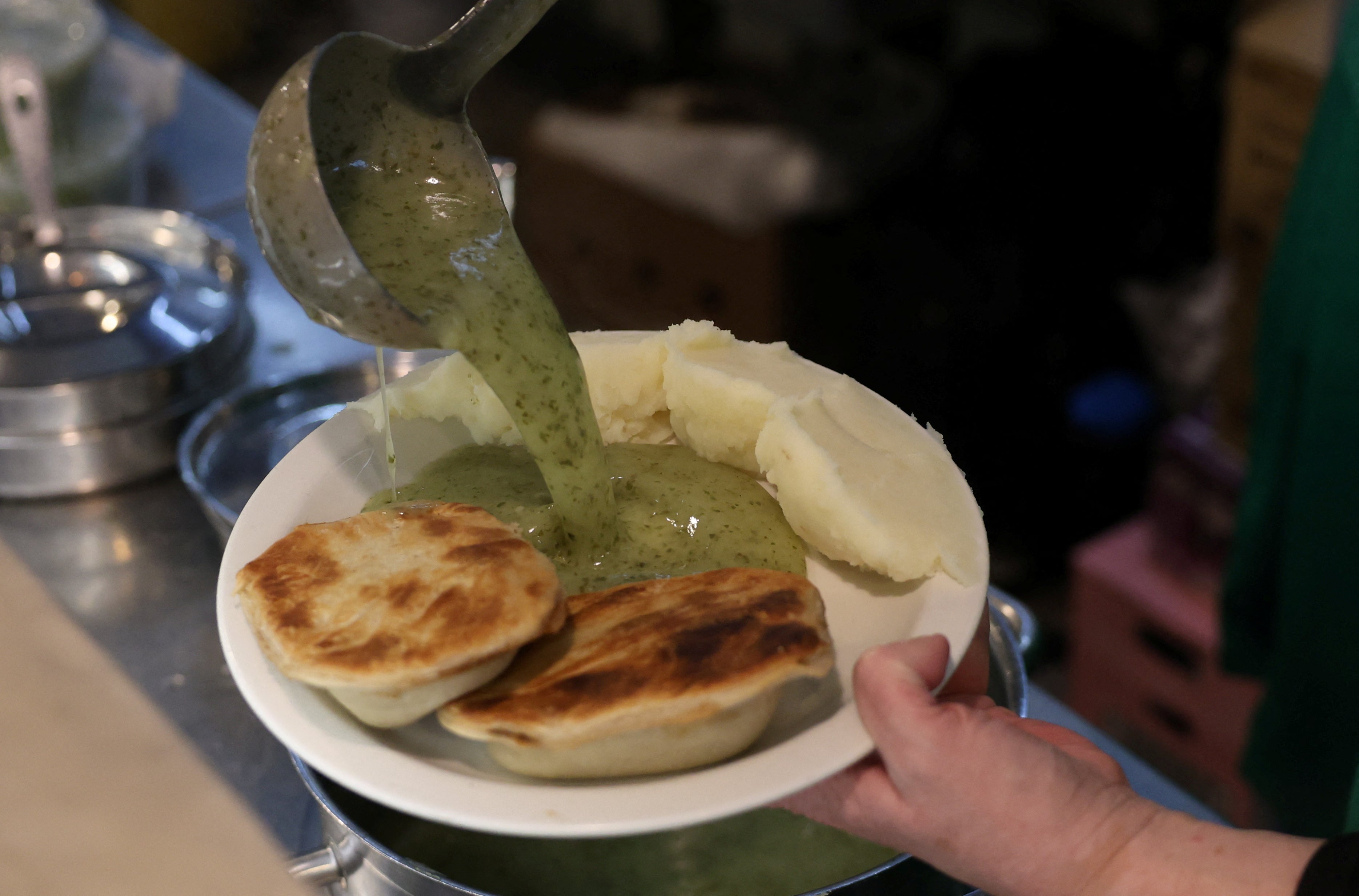 A plate of pie and mash with liquor sauce is prepared at M. Manze, in London, Britain, November 21