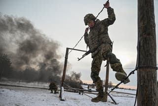 Ukrainian soldier balancing on a rope during military training