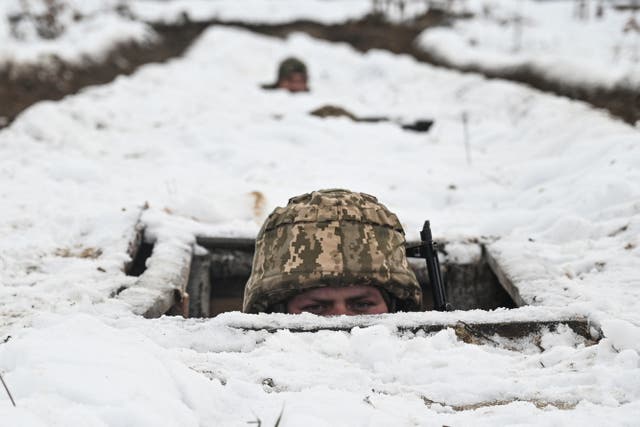 <p>A Ukrainian soldier’s head appears above the ground during a training exercise</p>