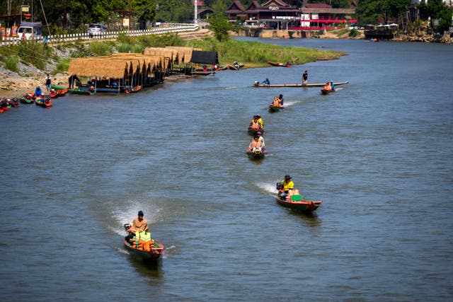 <p>Foreign tourists ride boats along the river in Vang Vieng</p>