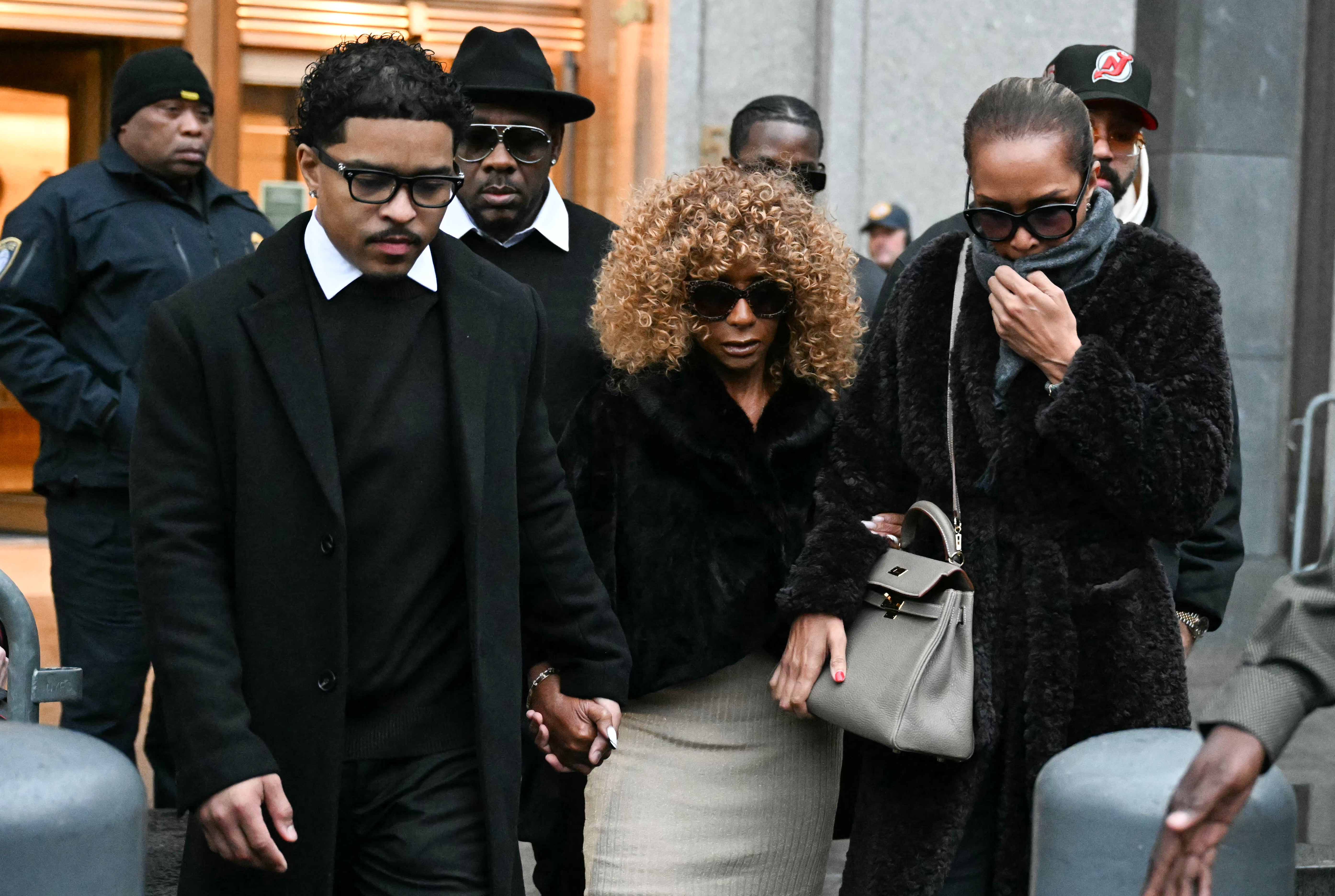 Janice Combs and her grandson Justin Dior Combs, left, leave court after the hearing