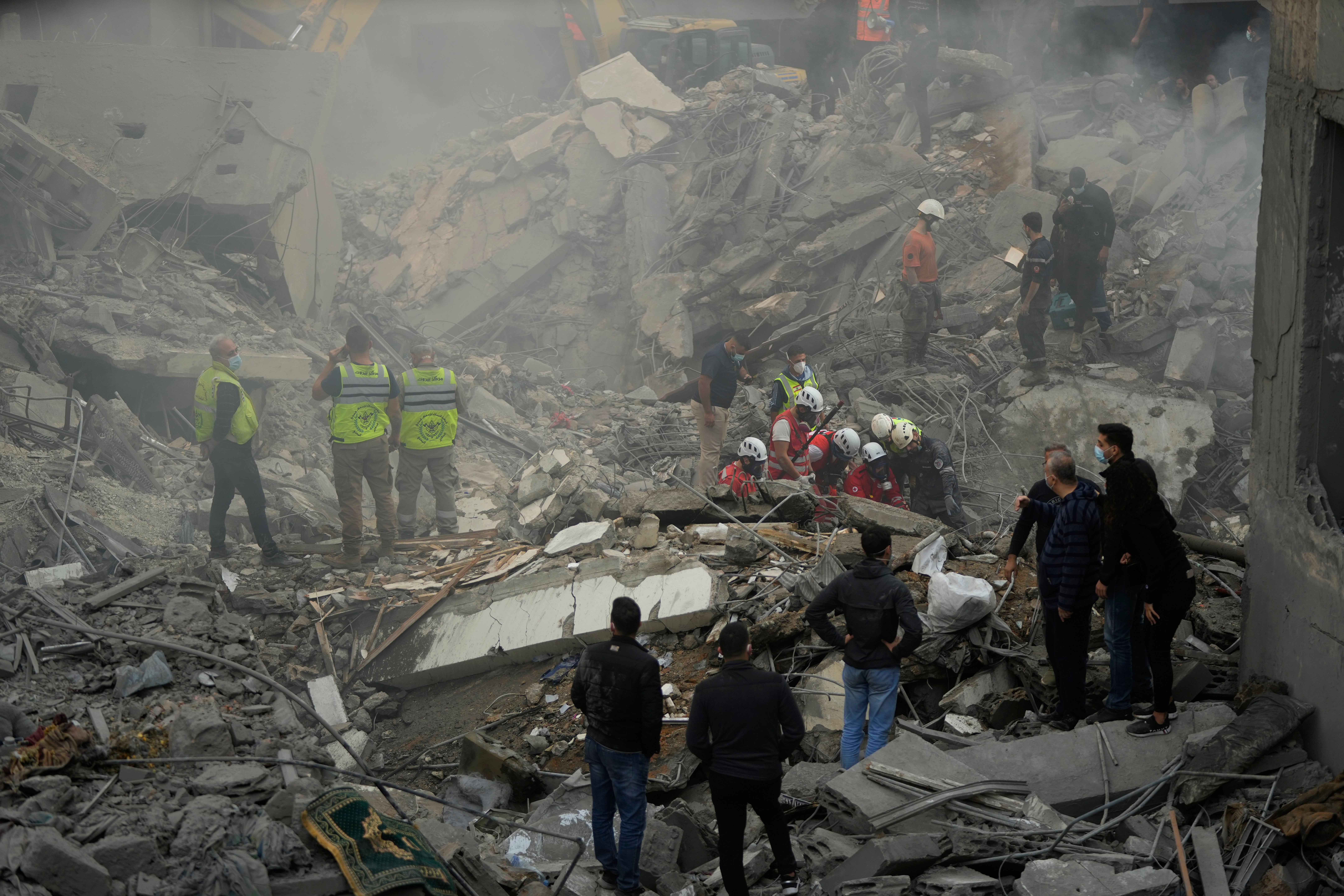 Rescue workers and volunteers search for victims at the site of an Israeli airstrike in central Beirut on 23 November 2024