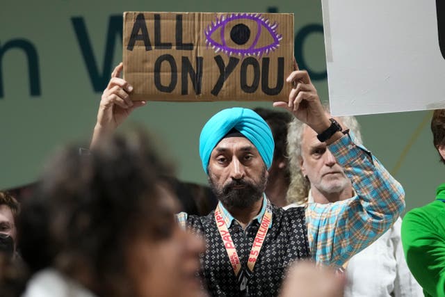Harjeet Singh holds a banner during a protest demanding climate finance from developed countries at Cop29 UN Climate Summit 