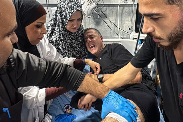 <p>Hossam Abu Safieh, director of the Kamal Adwan Hospital, is treated by colleagues for his injuries following an Israeli strike in Gaza </p>