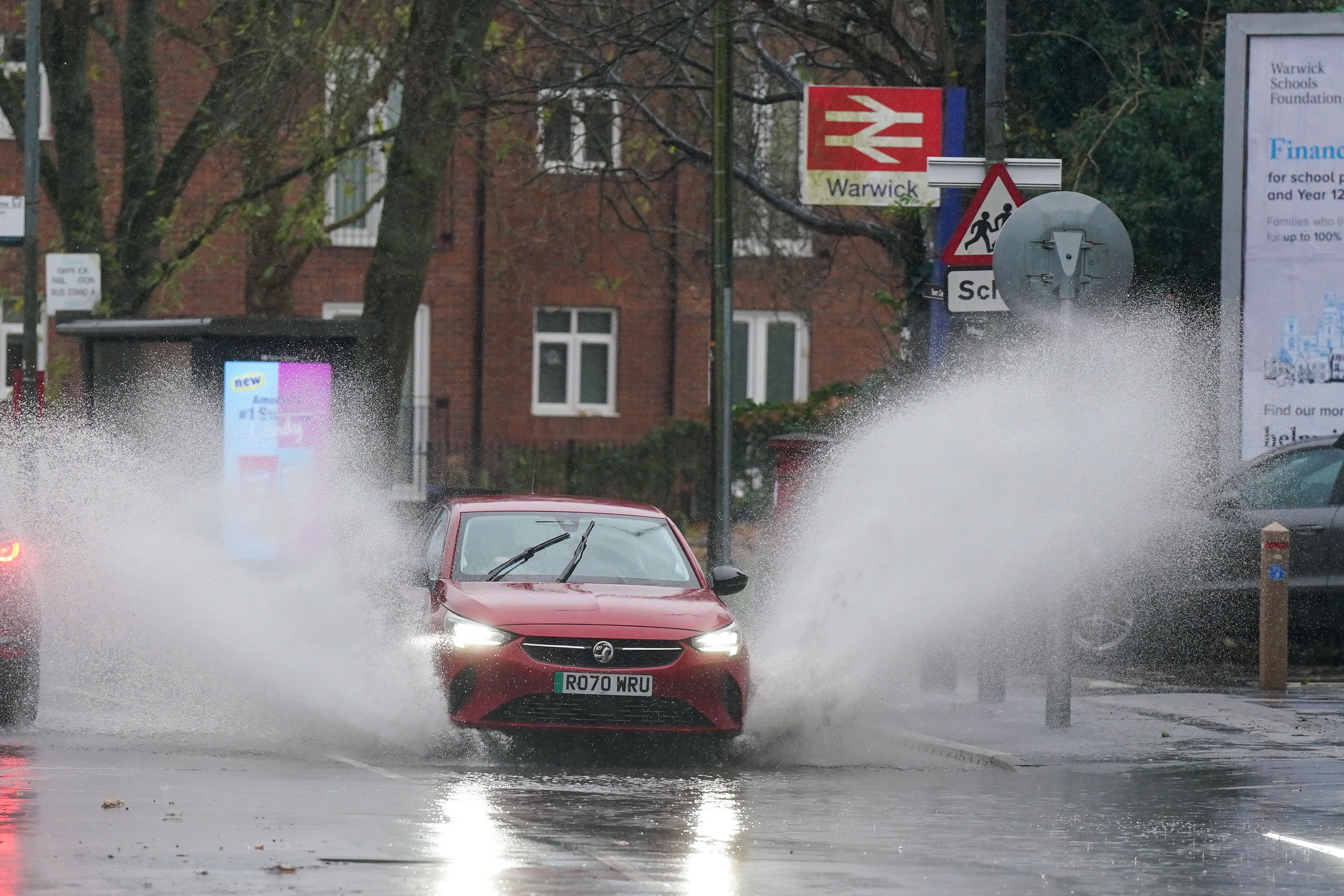 A vehicle is driven through floodwater after heavy rain in Warwick as Storm Bert continues to sweep across the country