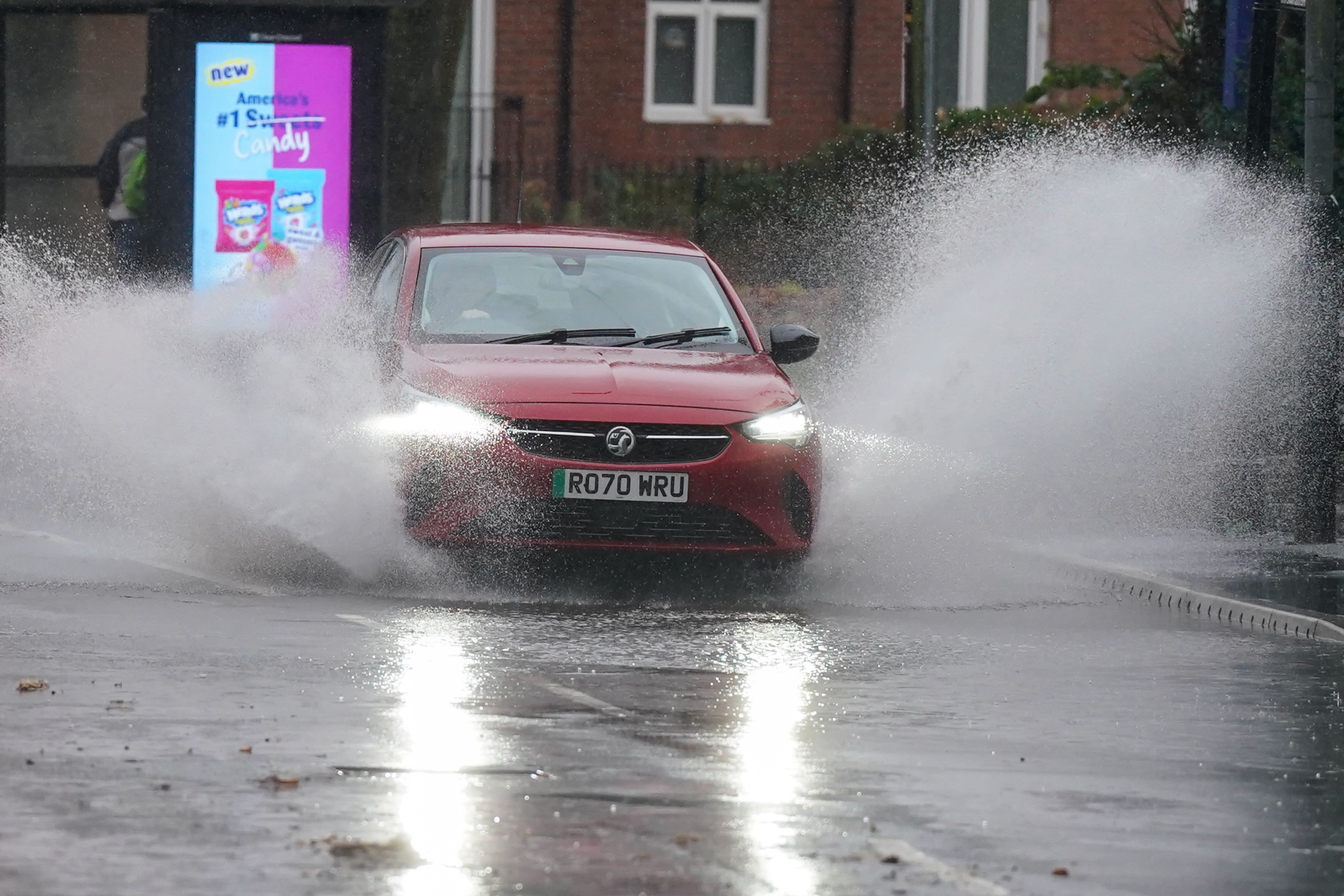 A vehicle is driven through floodwater after heavy rain in Warwick (Jacob King/PA)