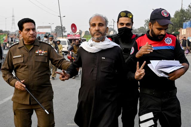 <p>Security personnel detain a supporter of jailed former prime minister Imran Khan’s Pakistan Tehreek-e-Insaf (PTI) party during a protest demanding his release in Lahore</p>