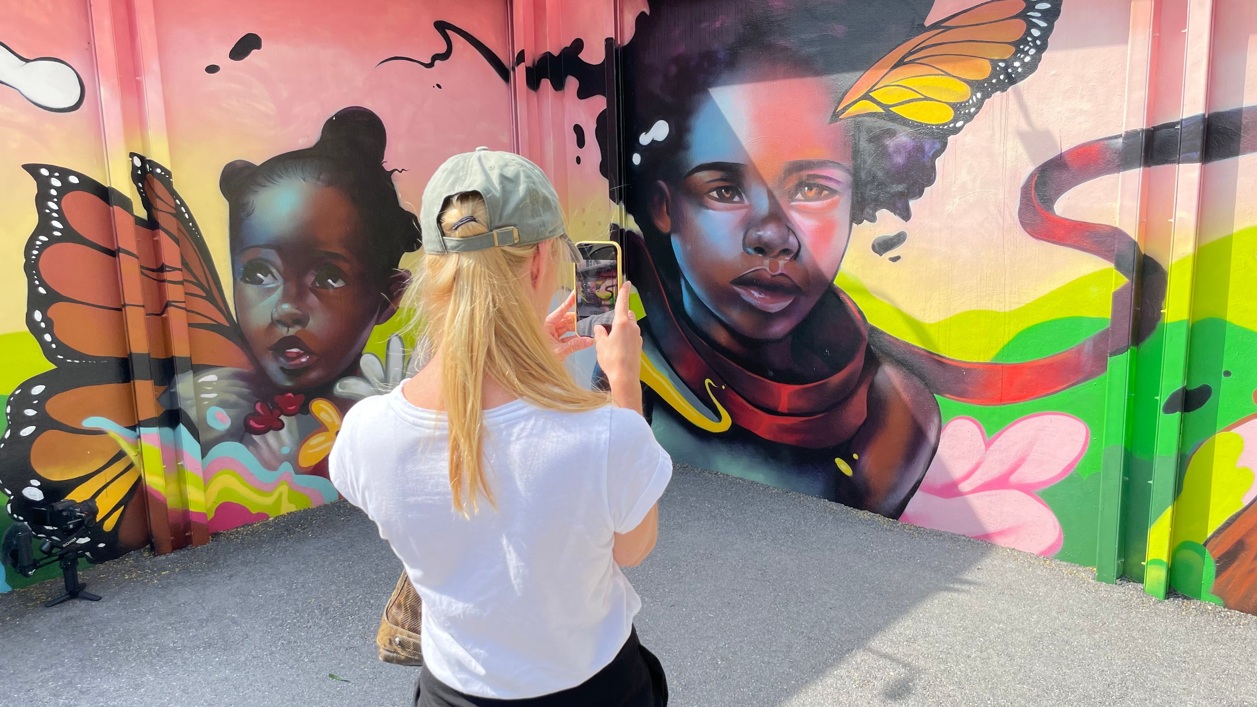 A visitor takes a photo of street art in the Wynwood Walls exhibition