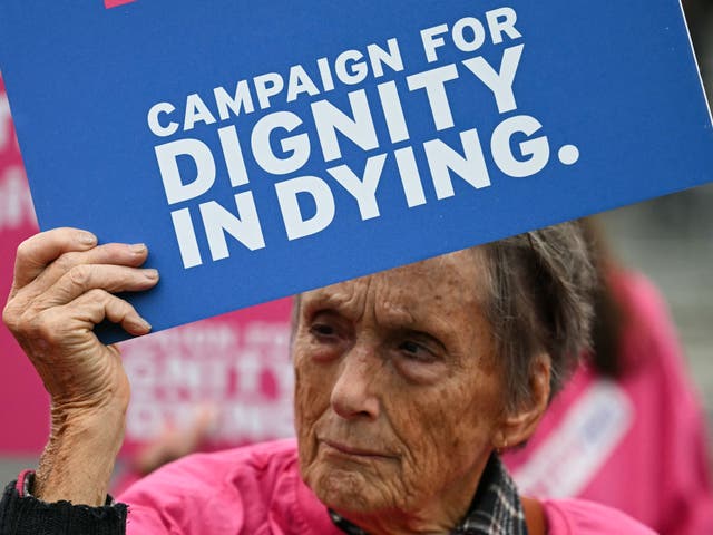 <p>A campaigner from “Dignity in Dying” holds a placard during a demonstration outside The Palace of Westminster </p>