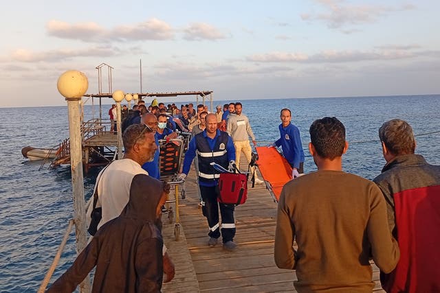 <p>Medics and people wait for possible survivors after a boat sank at a harbour in Marsa Alam, Red Sea Governorate, in Egypt</p>