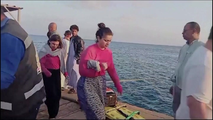 Survivors of boat sunk off Red Sea coast disembark from a rescue vessel