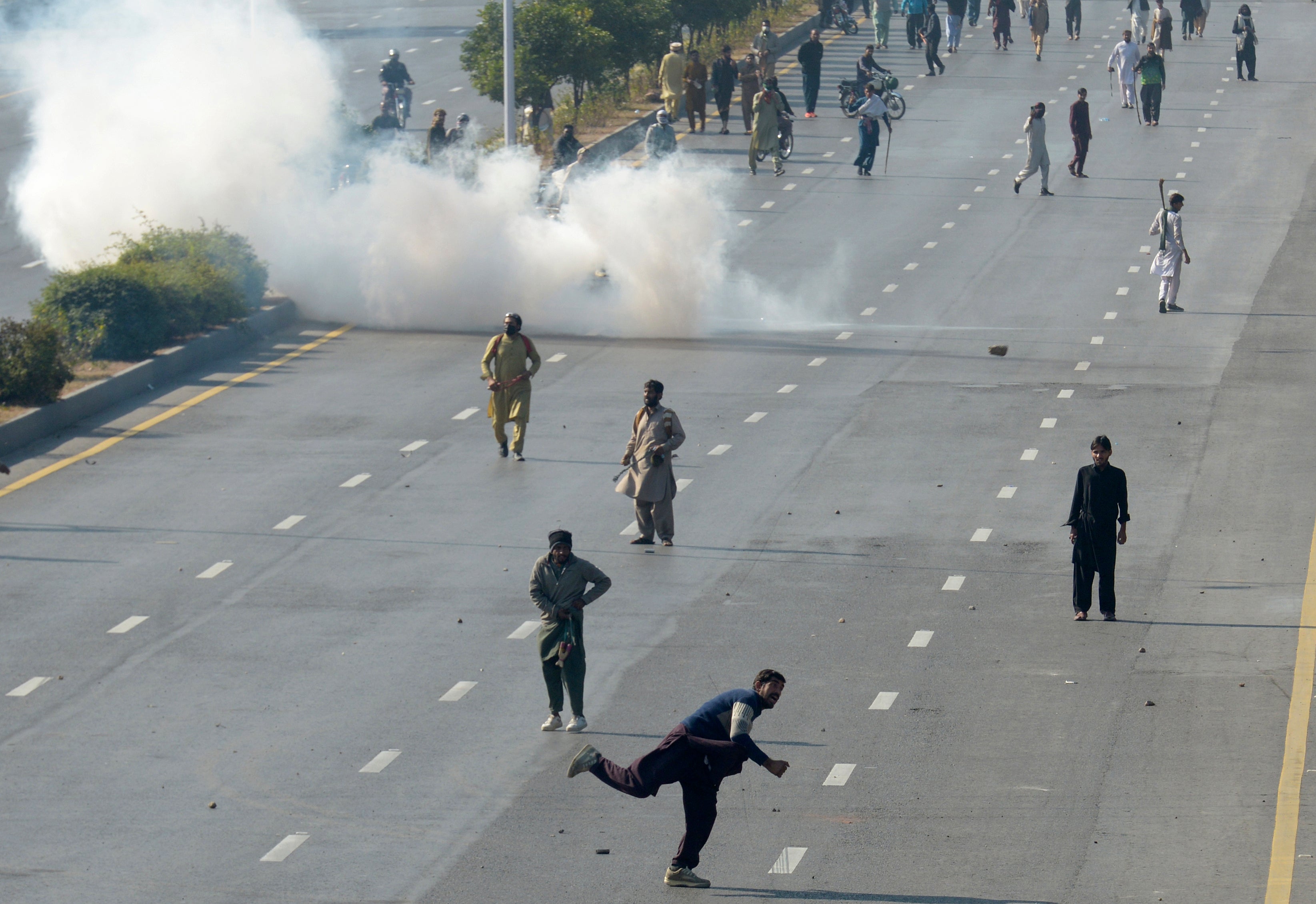 Supporters of imprisoned former premier Imran Khan's Pakistan Tehreek-e-Insaf party, throw stones as police fire tear gas shell to disperse them