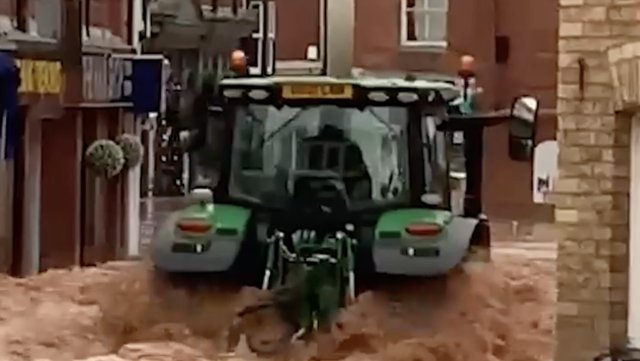 <p>The tractor was seen causing damage to shops as it drove through a flooded street  </p>