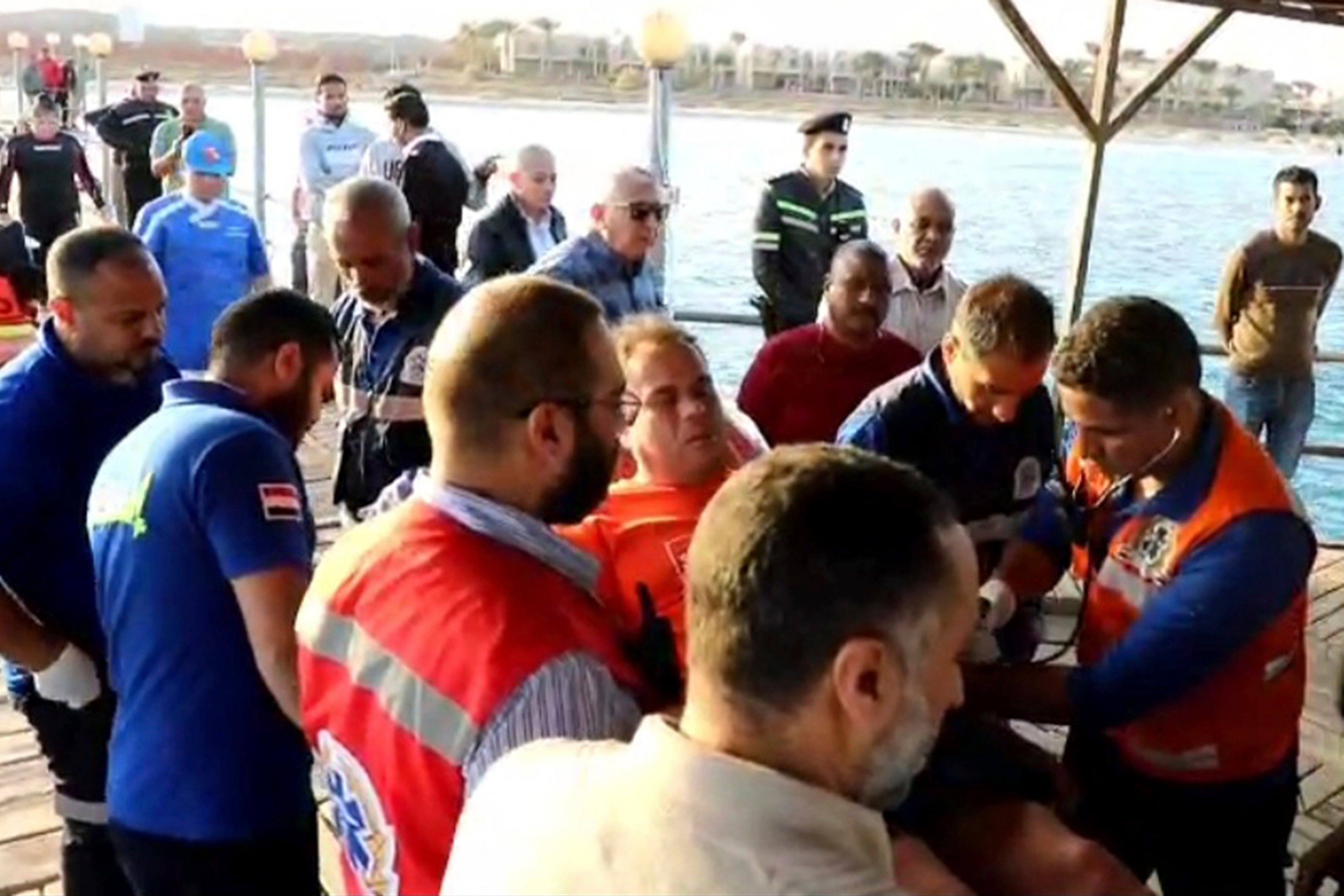 Rescue workers transport a survivor of the boat