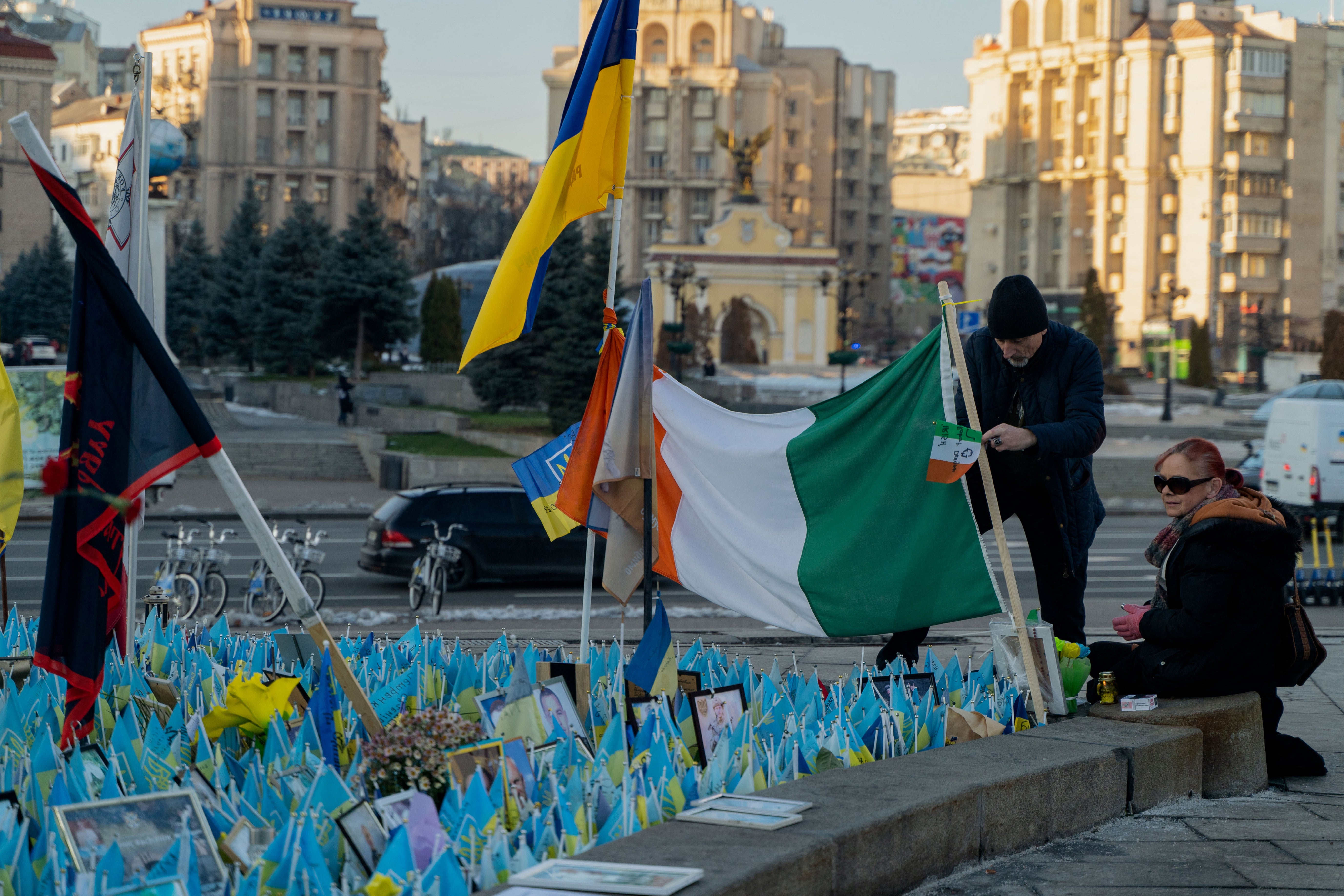 People visit the makeshift memorial paying tribute to Ukrainian and foreign fighters at the Independence Square in Kyiv