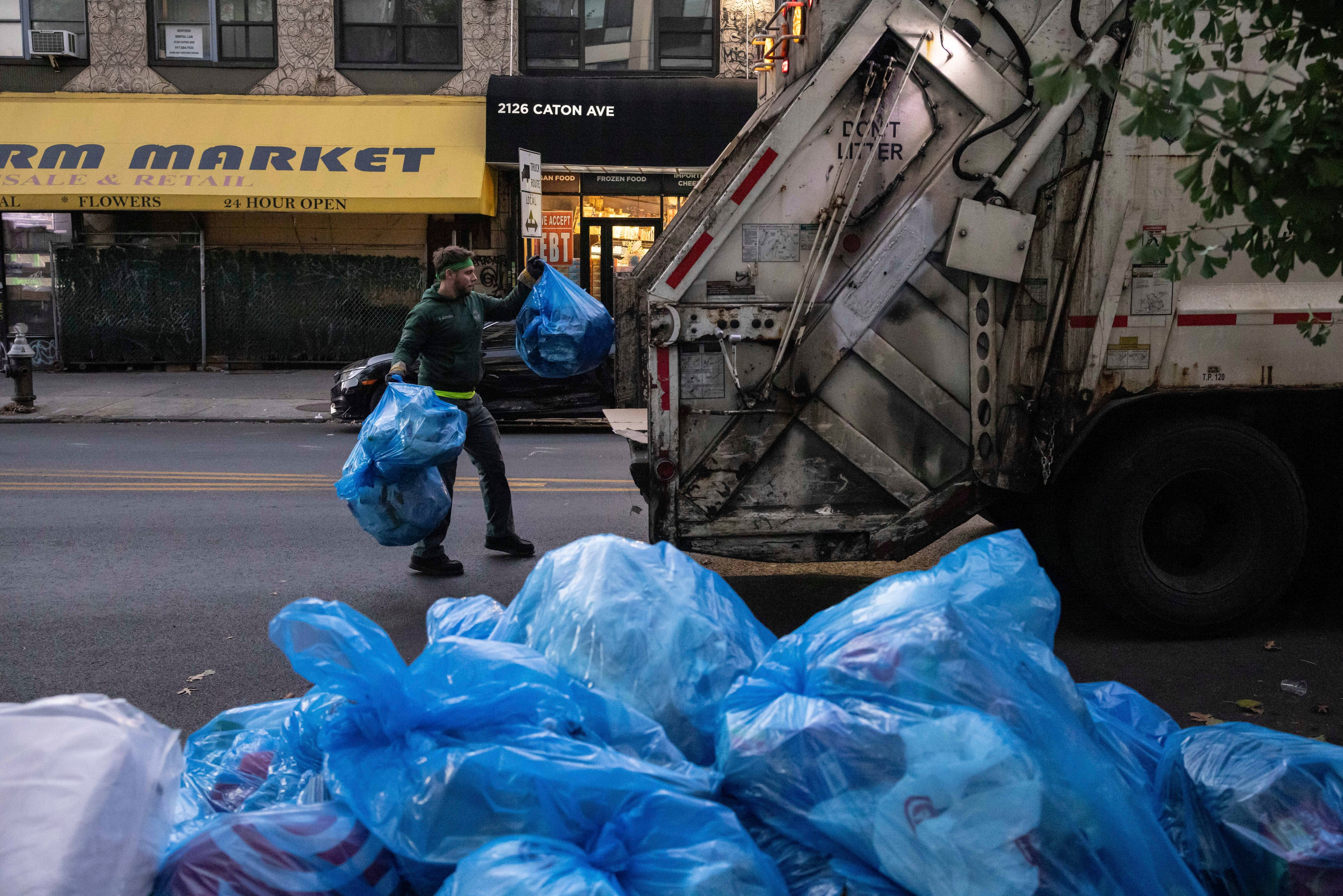 A sanitation worker collects trash, Saturday, Nov. 16, 2024, in the Brooklyn borough of New York