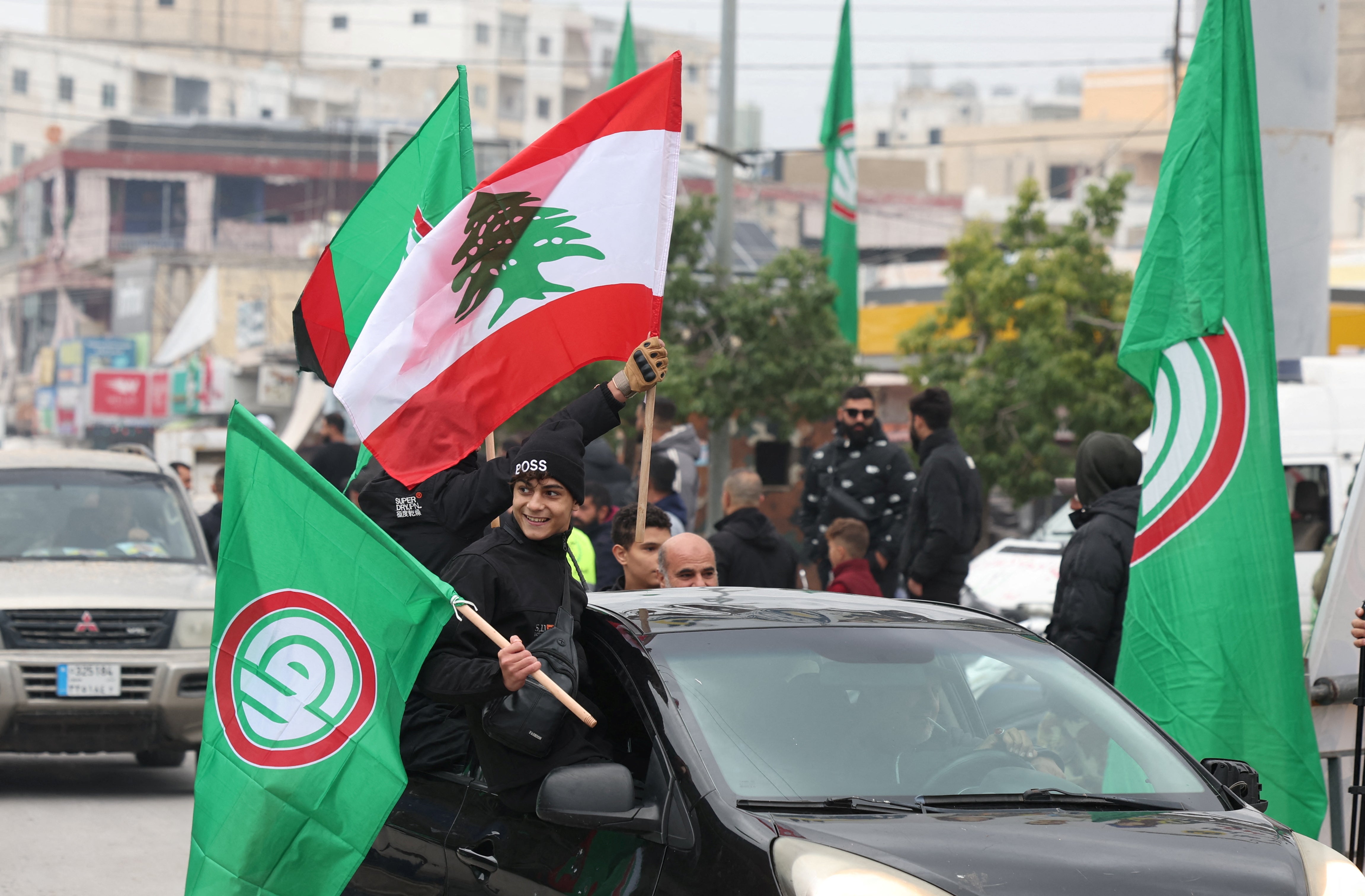 People wave Lebanese and Amal movement flags