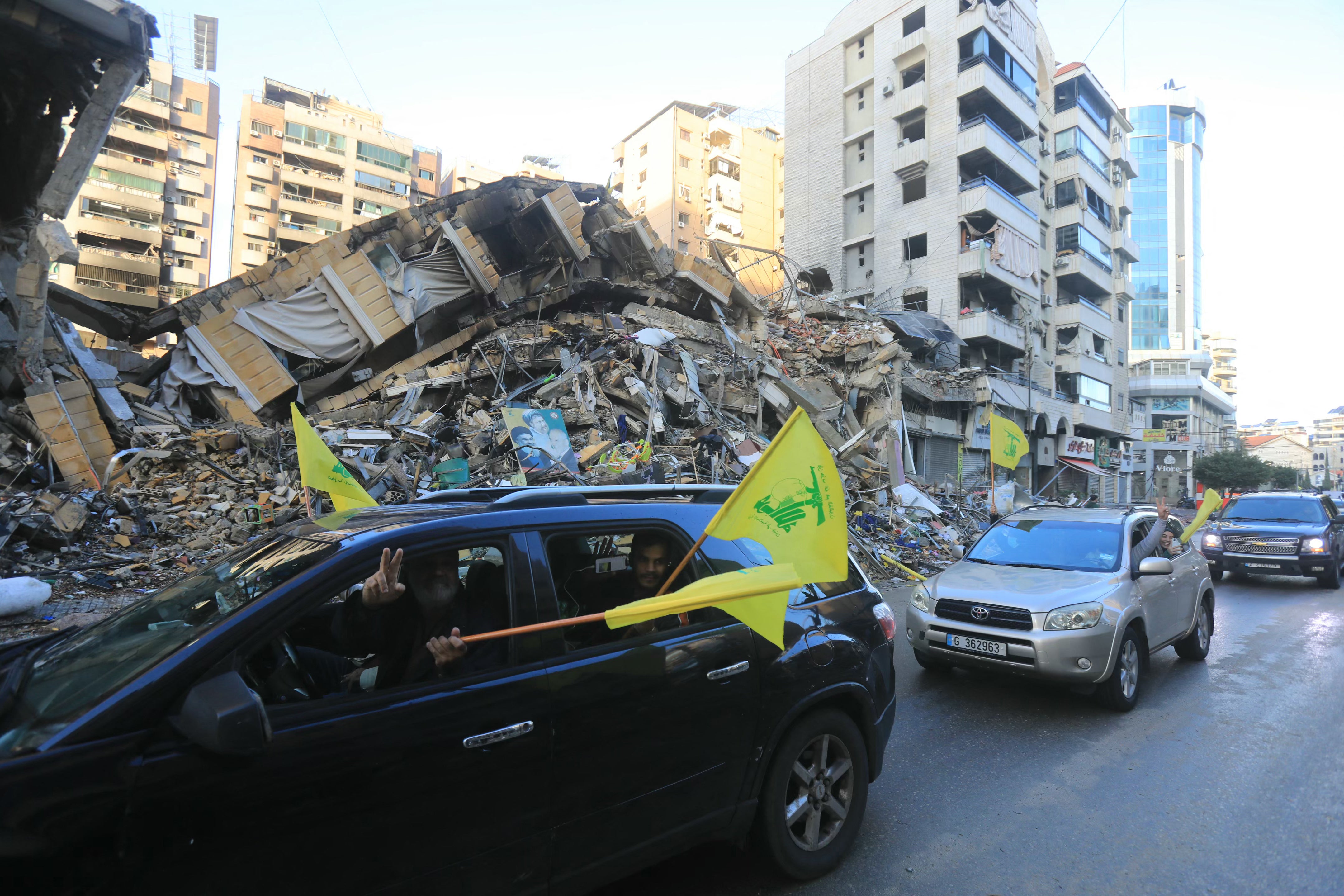 Motorists wave the flag of Hezbollah as they parade in Beirut’s southern suburbs