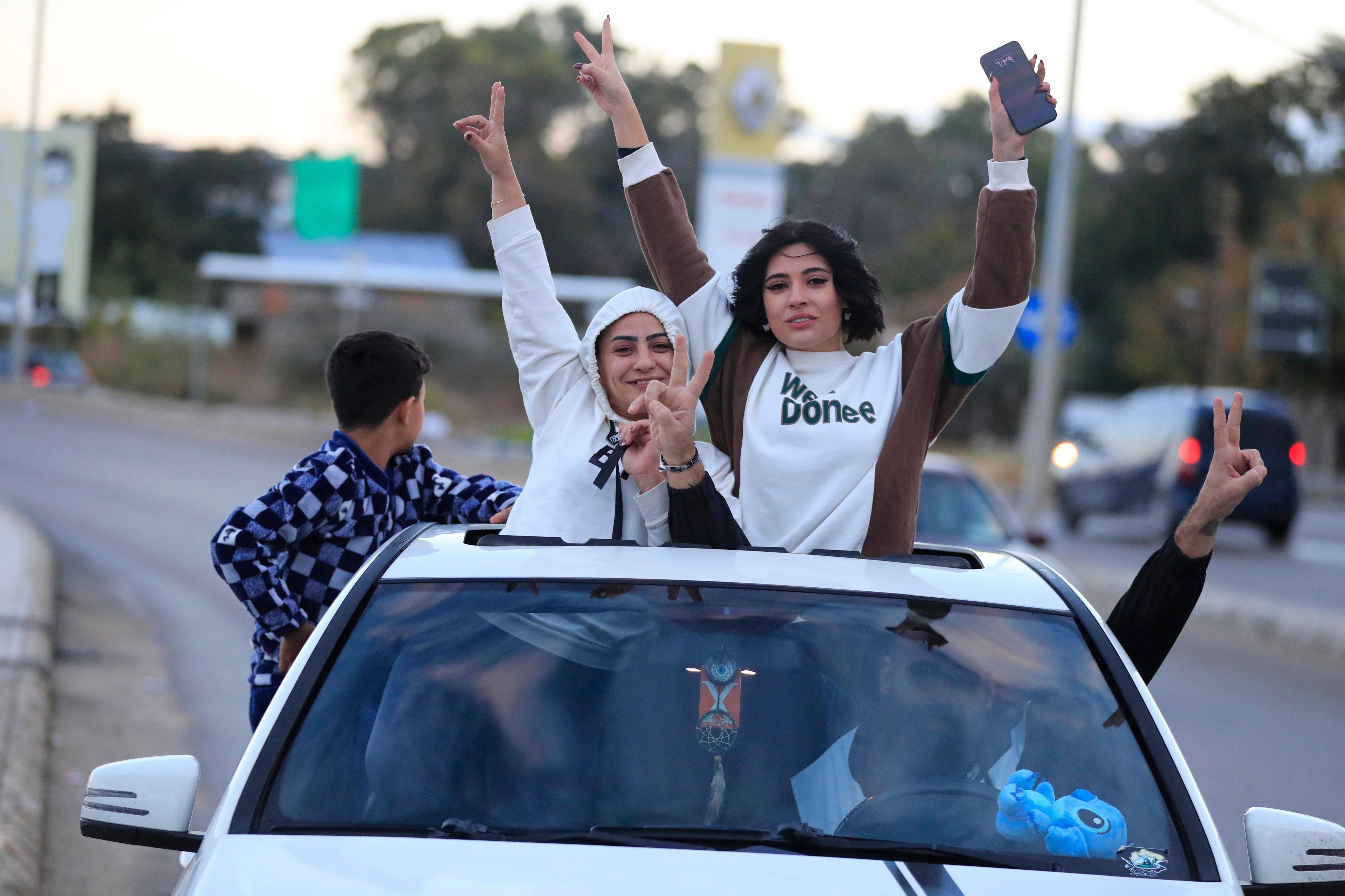 People celebrate after the ceasefire between Israel and Hezbollah went into effect in Sidon, Lebanon