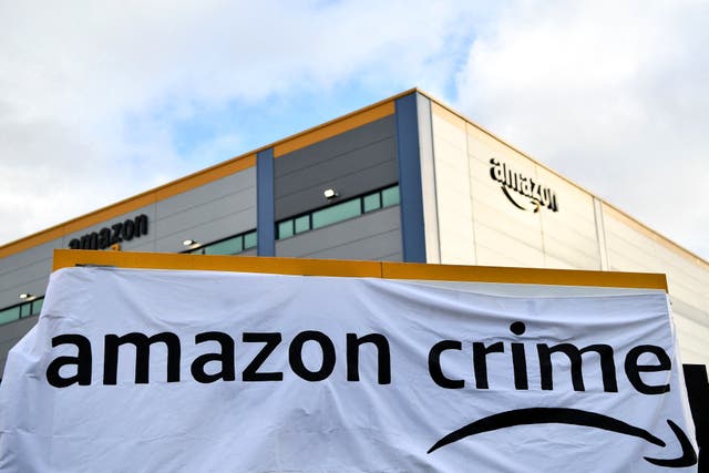 <p>A banner is pictured outside an Amazon distribution centre in Tilbury, east of London, on 26 November, 2021</p>