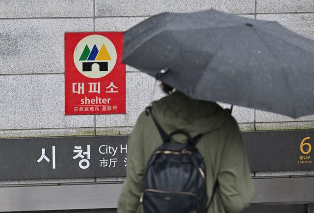 <p>Representative: A woman holding an umbrella, while waiting on a subway station in Seoul</p>