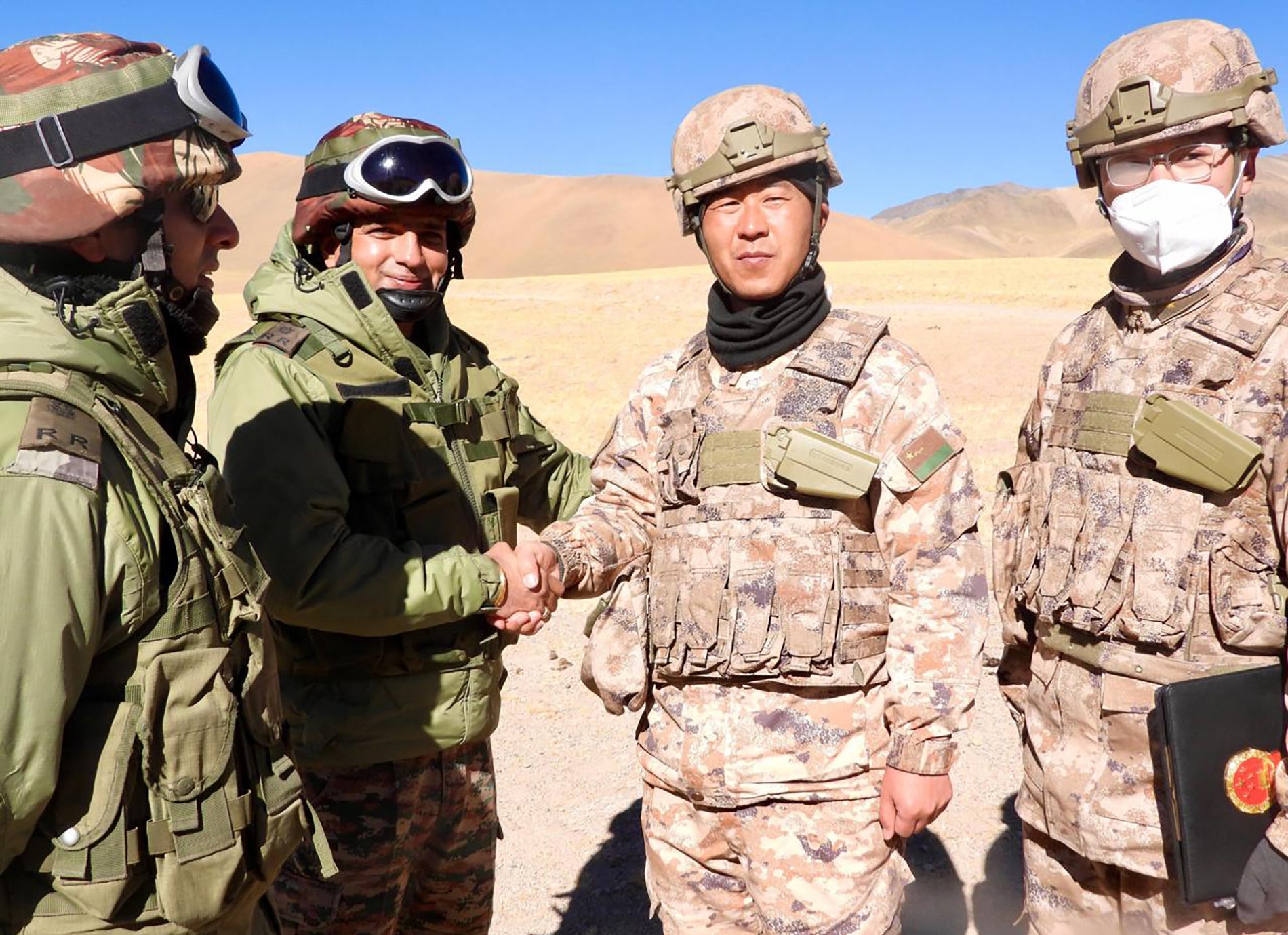 Indian and Chinese soldiers greet each other along the Line of Actual Control near Karakoram Pass in Ladakh on 31 October 2024