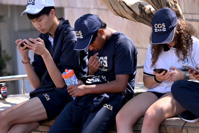 <p>Students look at their phones in Melbourne on 28 November 2024 </p>