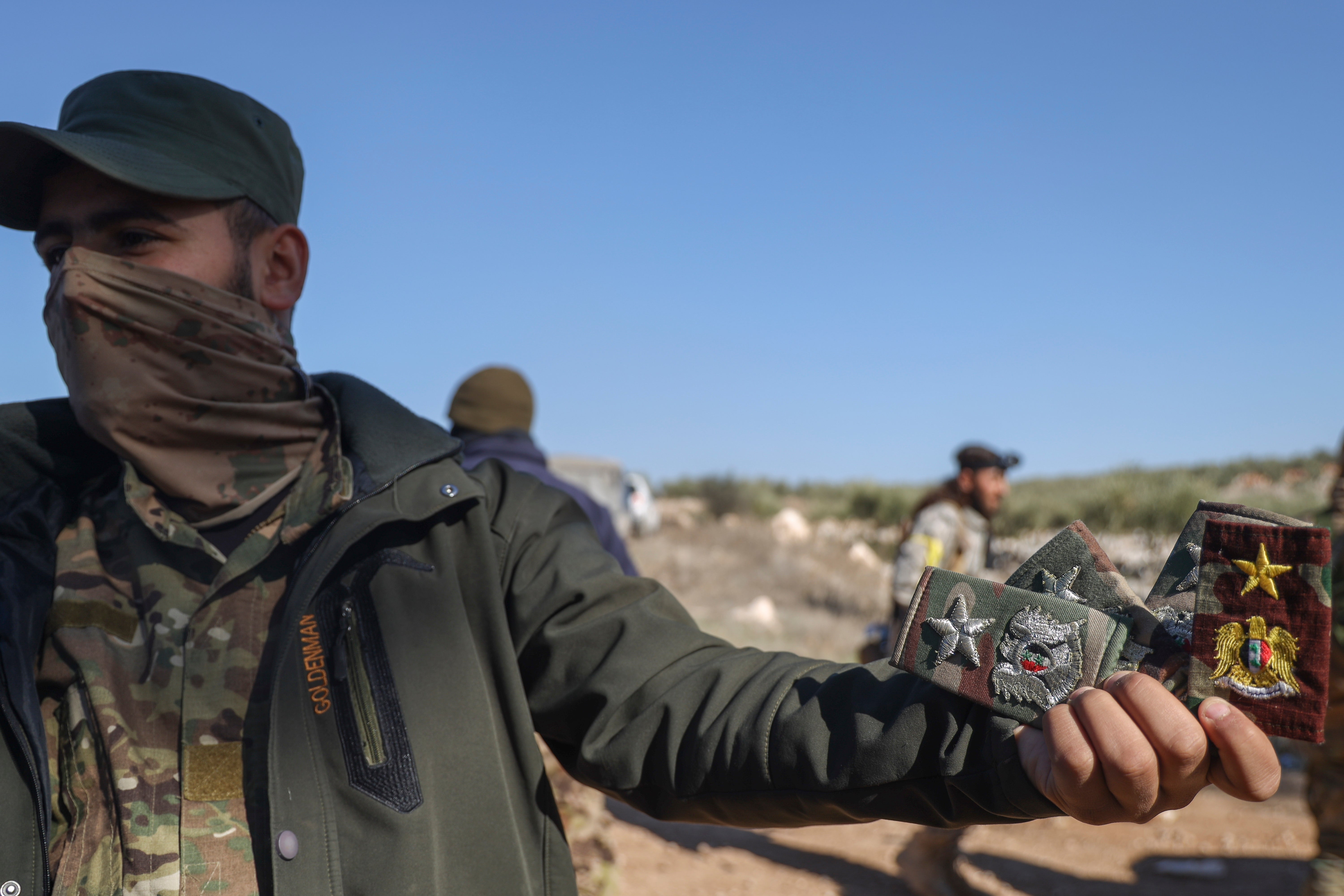 <p>A Syrian opposition fighter, with badges reportedly belonging to Syrian army officers, on the outskirts of Aleppo</p>