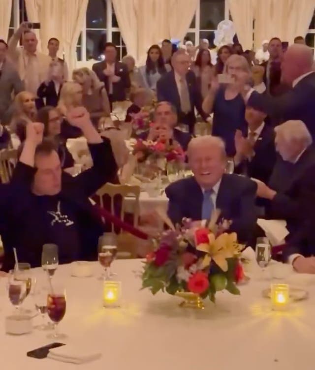 <p>Elon Musk and Donald Trump ‘groove’ to <em>YMCA</em> at the Mar-a-Lago Thanksgiving celebration as Barron watches out of the shot next to his dad</p>