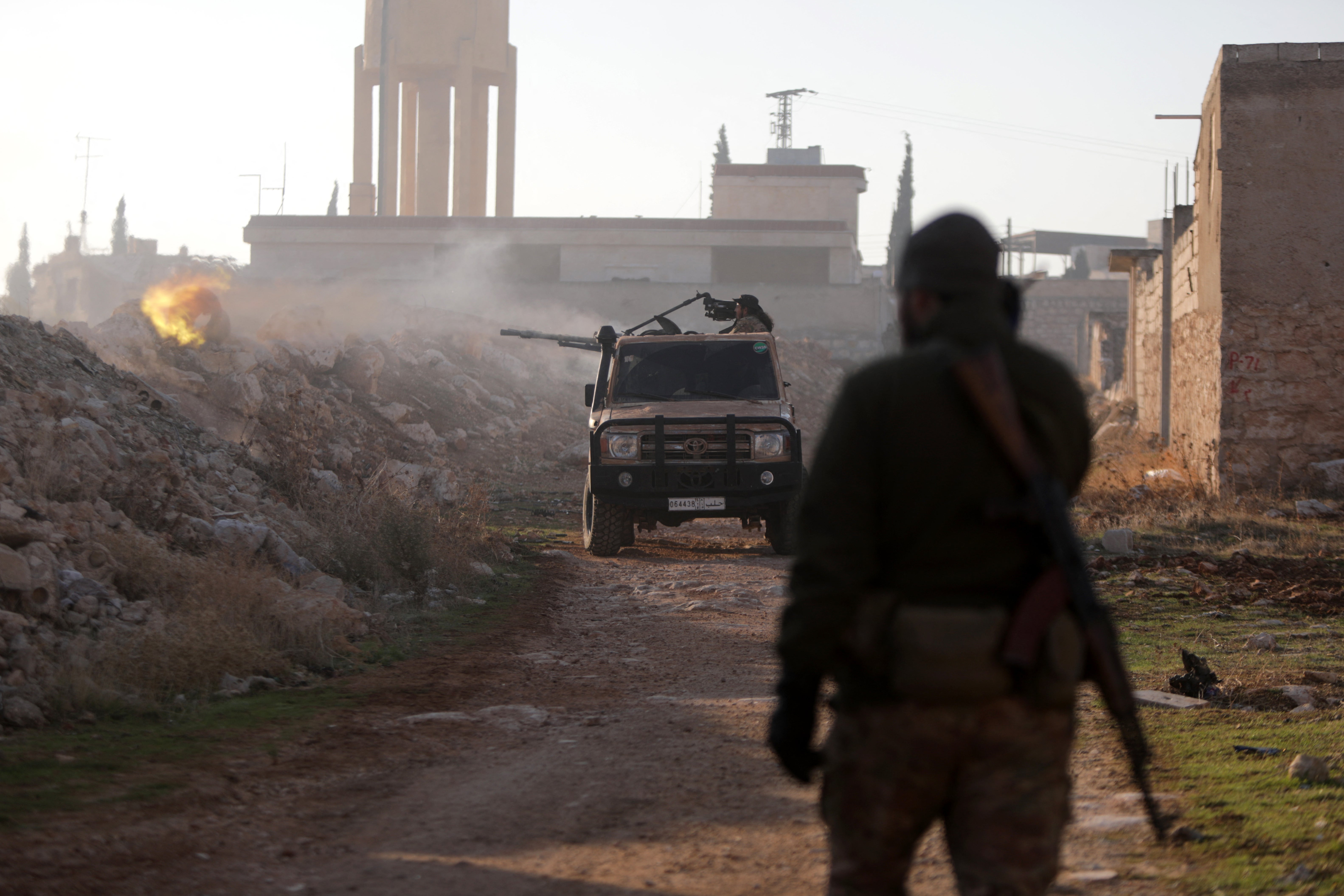 Fighters fire towards Syrian army troops in the Rashidin district on the outskirts of Aleppo on Friday