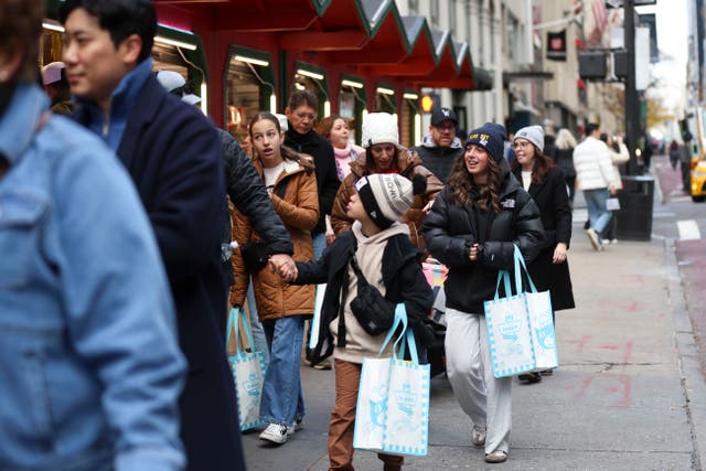 <p>Shoppers walk along Fifth Avenue, Friday, 29 November 2024 in New York</p>