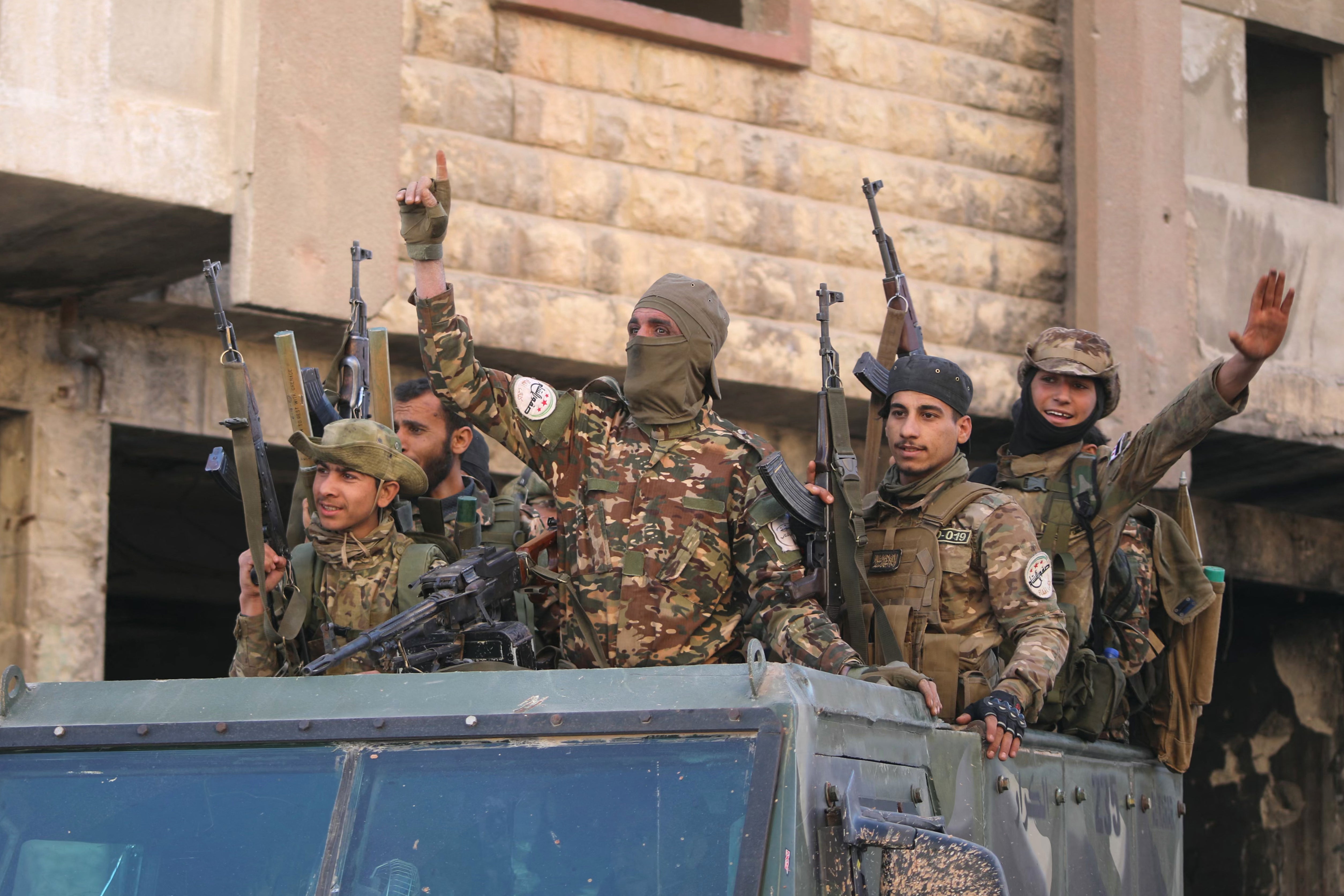 Anti-government fighters celebrate in a street in Maaret al-Numan in Syria’s northwestern Idlib province