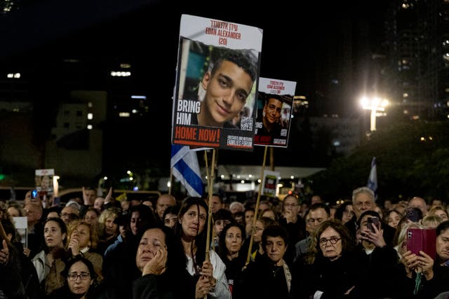 <p>Protesters hold up photos of hostage Eden Alexander during a rally calling on Israeli prime minster Benjamin Netanyahu to end the war in Gaza</p>