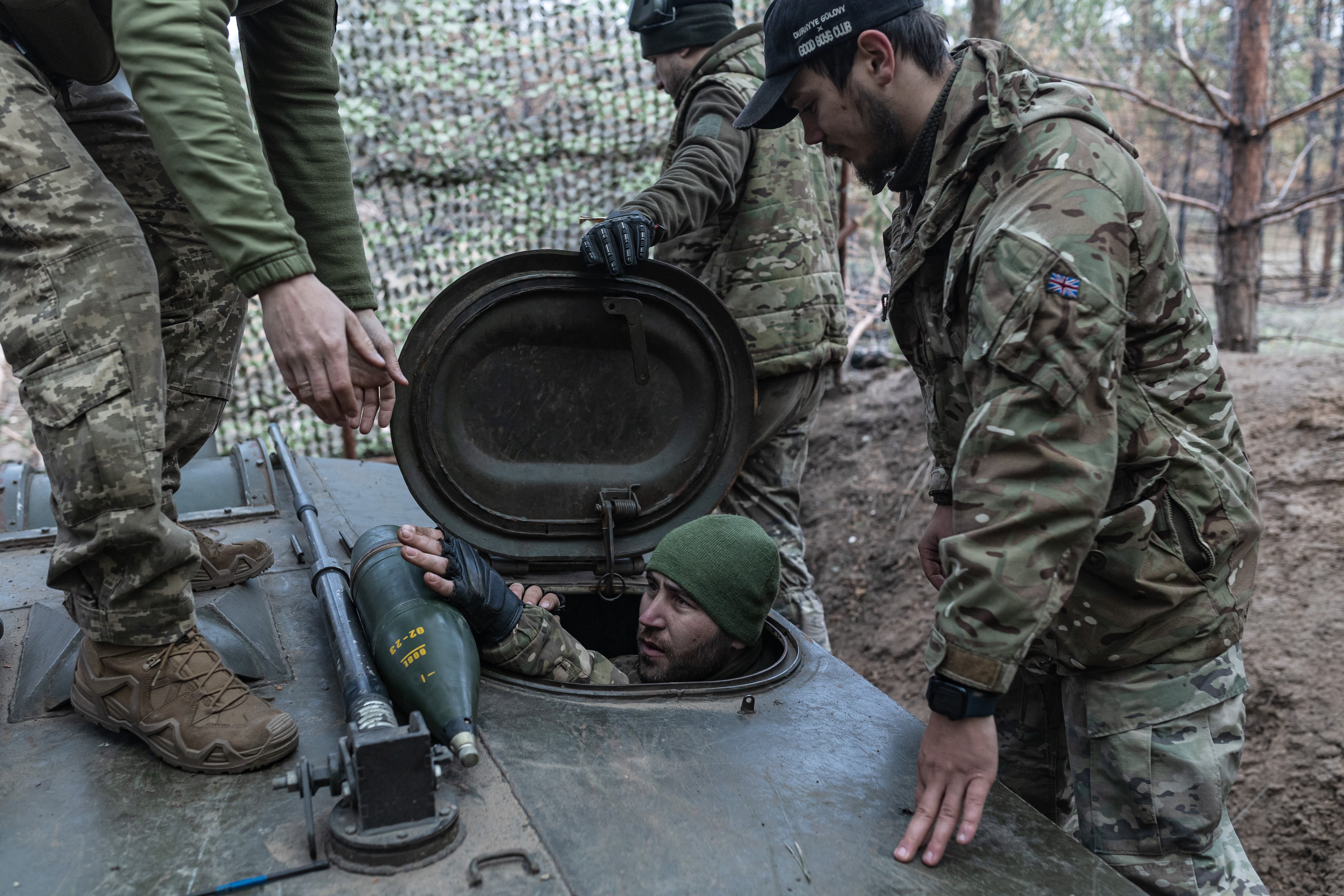 Ukrainian soldiers load ammunition into a Soviet-era 2S1 Gvozdika self-propelled artillery system in the direction of Kreminna