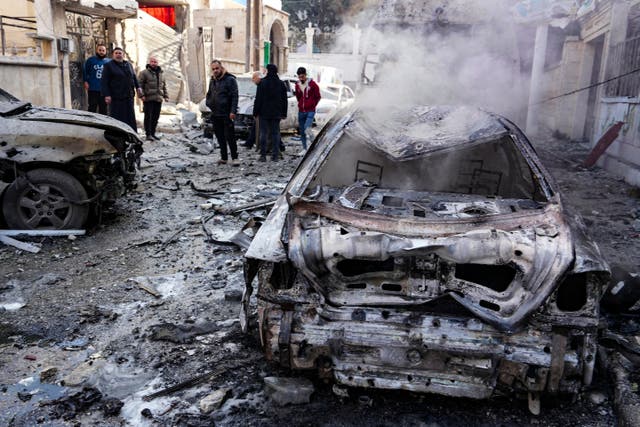 <p>People check the damage at the scene of a Syrian regime airforce strike that targeted a neighbourhood in Syria's rebel-held northern city of Idlib</p>